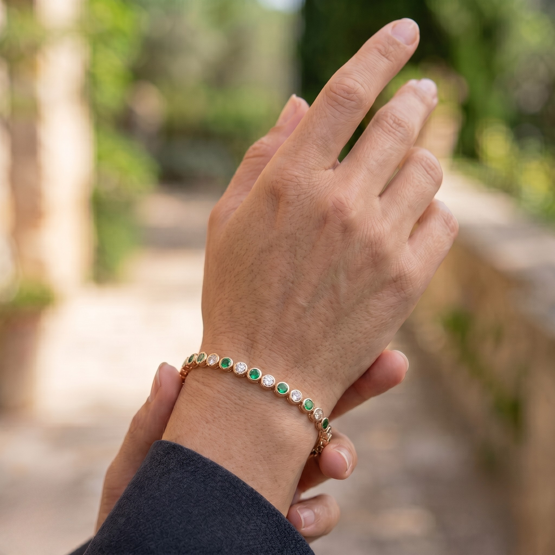 Alternating green gemstone and white diamond bracelet with round bezel-set stones.