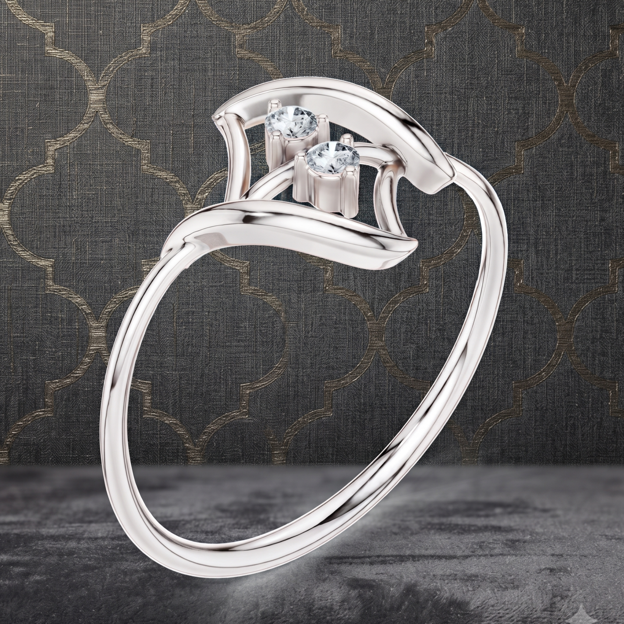 A polished silver-tone ring with two clear gemstones, shown floating against a dark textured background with a subtle gold trellis pattern.