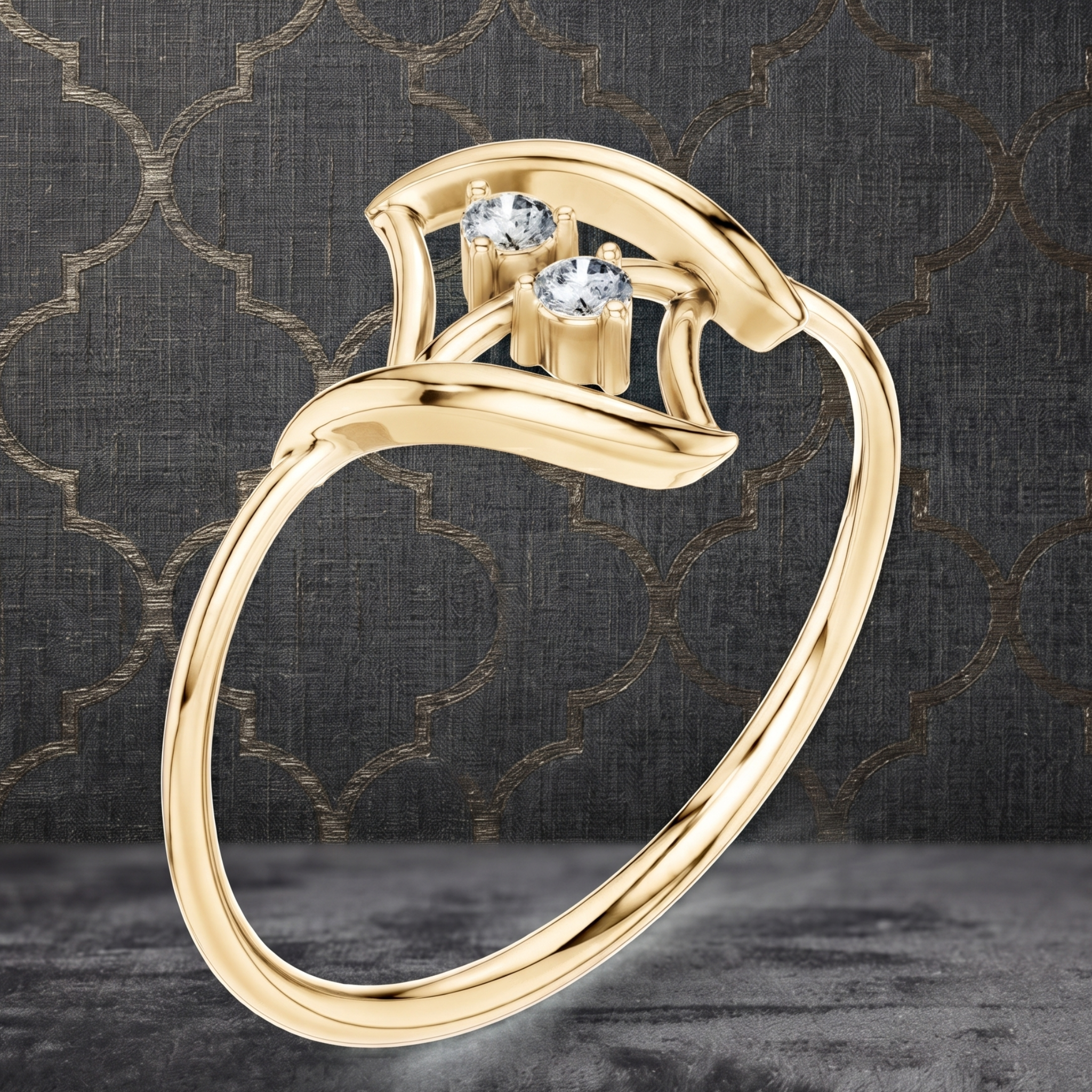 A gold ring with a curved, openwork band and two small clear gemstones at the top, shown on a dark patterned background.
