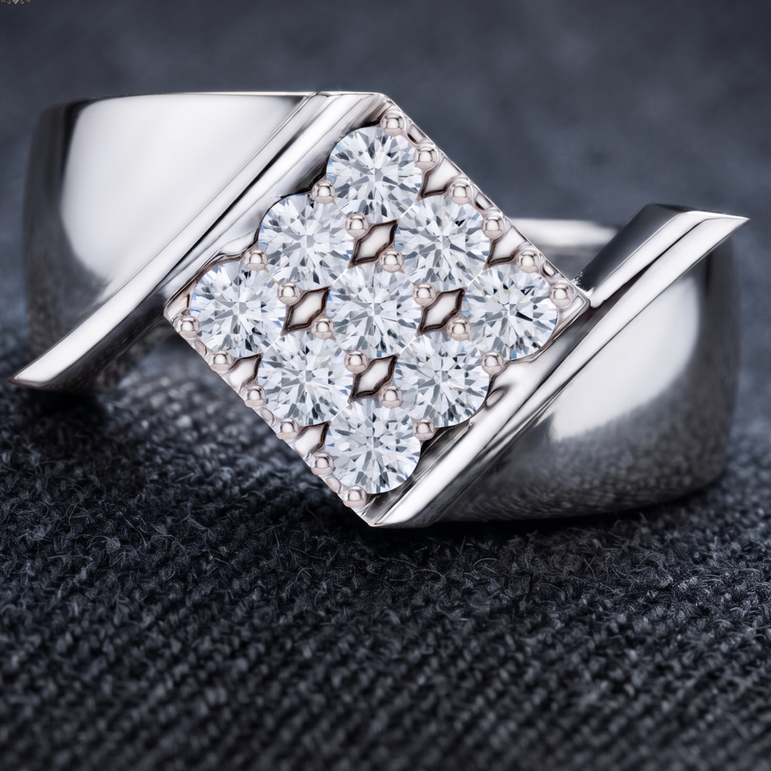 A silver-toned ring with a square cluster of clear gemstones in a prong setting, photographed close up on a dark textured surface.