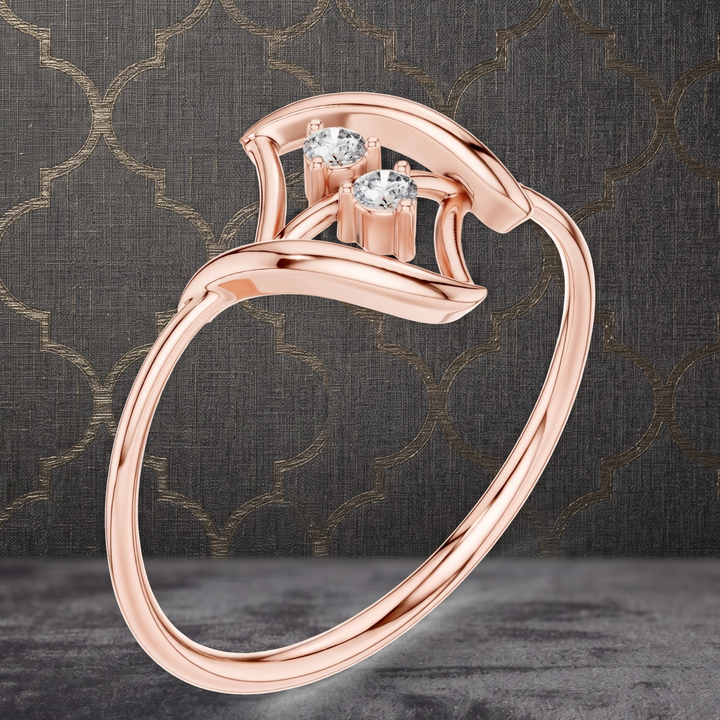 A rose gold ring with a curved openwork band and two clear gemstones, shown on a dark textured background with a subtle geometric pattern.
