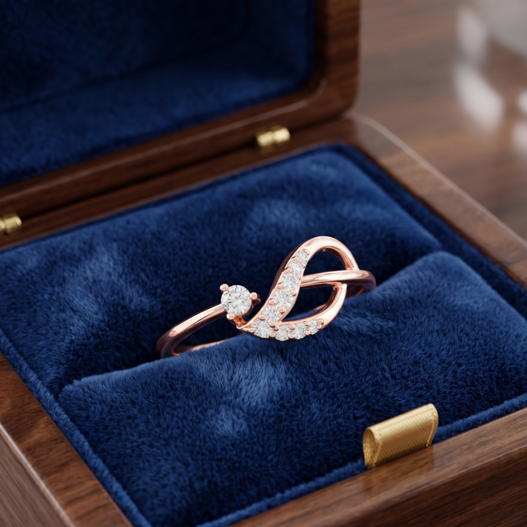 A rose gold ring with a curved, diamond-encrusted design resting inside an open wooden jewelry box lined with deep blue velvet.