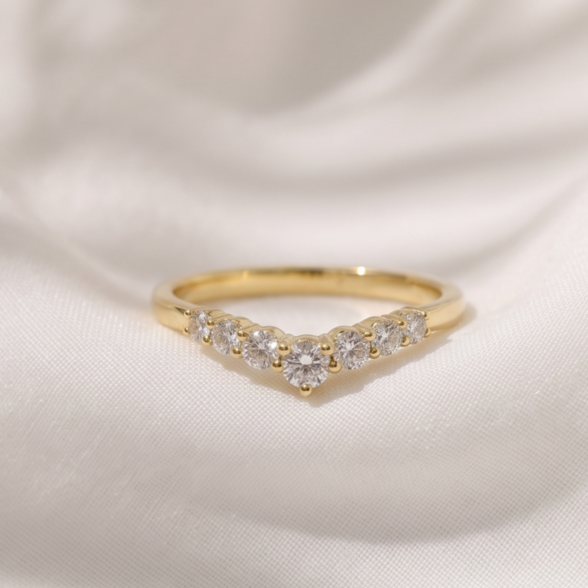 0.53 CT graduated round diamond curved wedding band in yellow gold