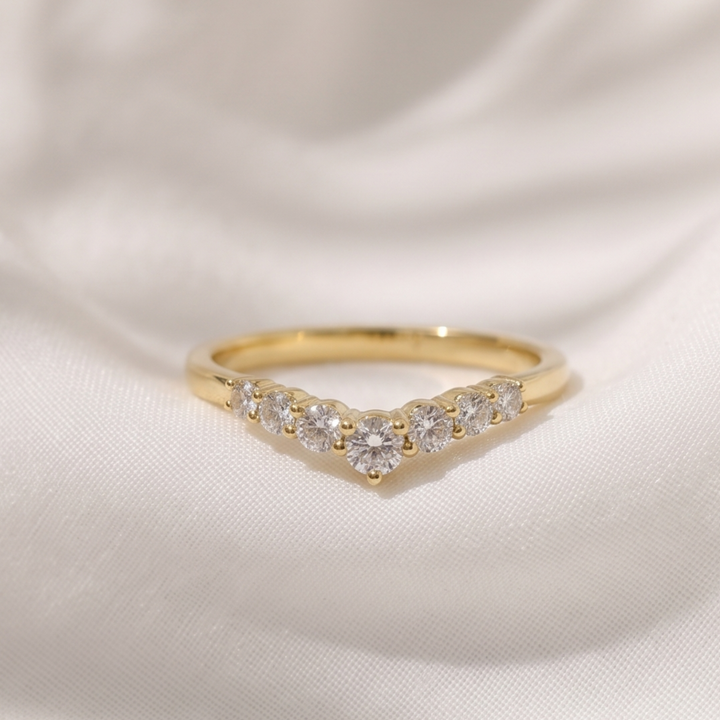 0.53 CT graduated round diamond curved wedding band in yellow gold