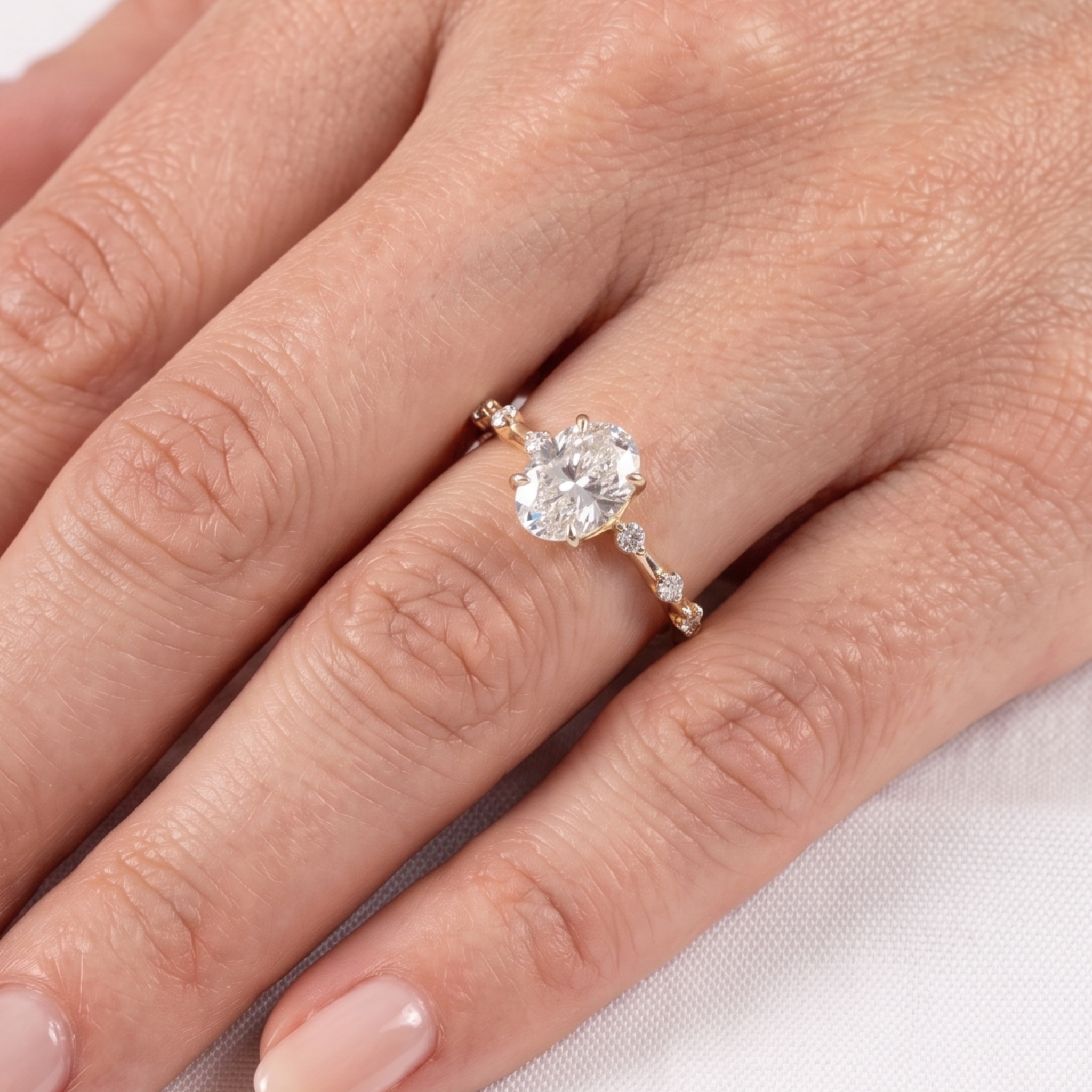 Elegant oval center diamond ring with round and marquise-inspired side stones.