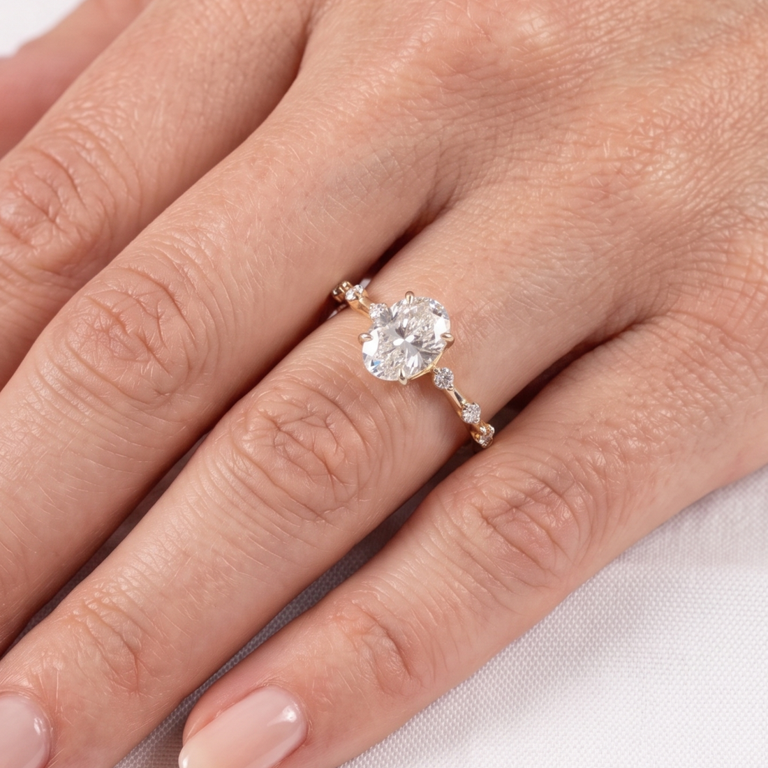 Elegant oval center diamond ring with round and marquise-inspired side stones.