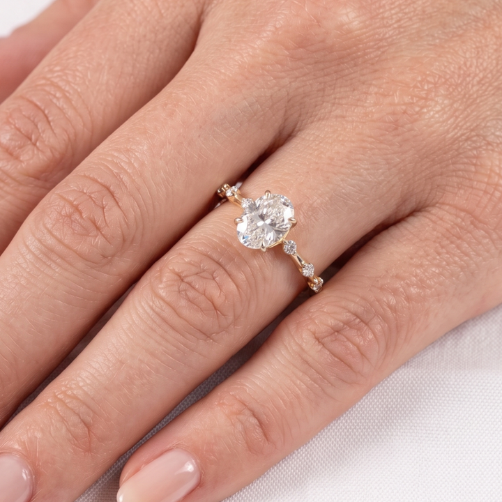 Elegant oval center diamond ring with round and marquise-inspired side stones.