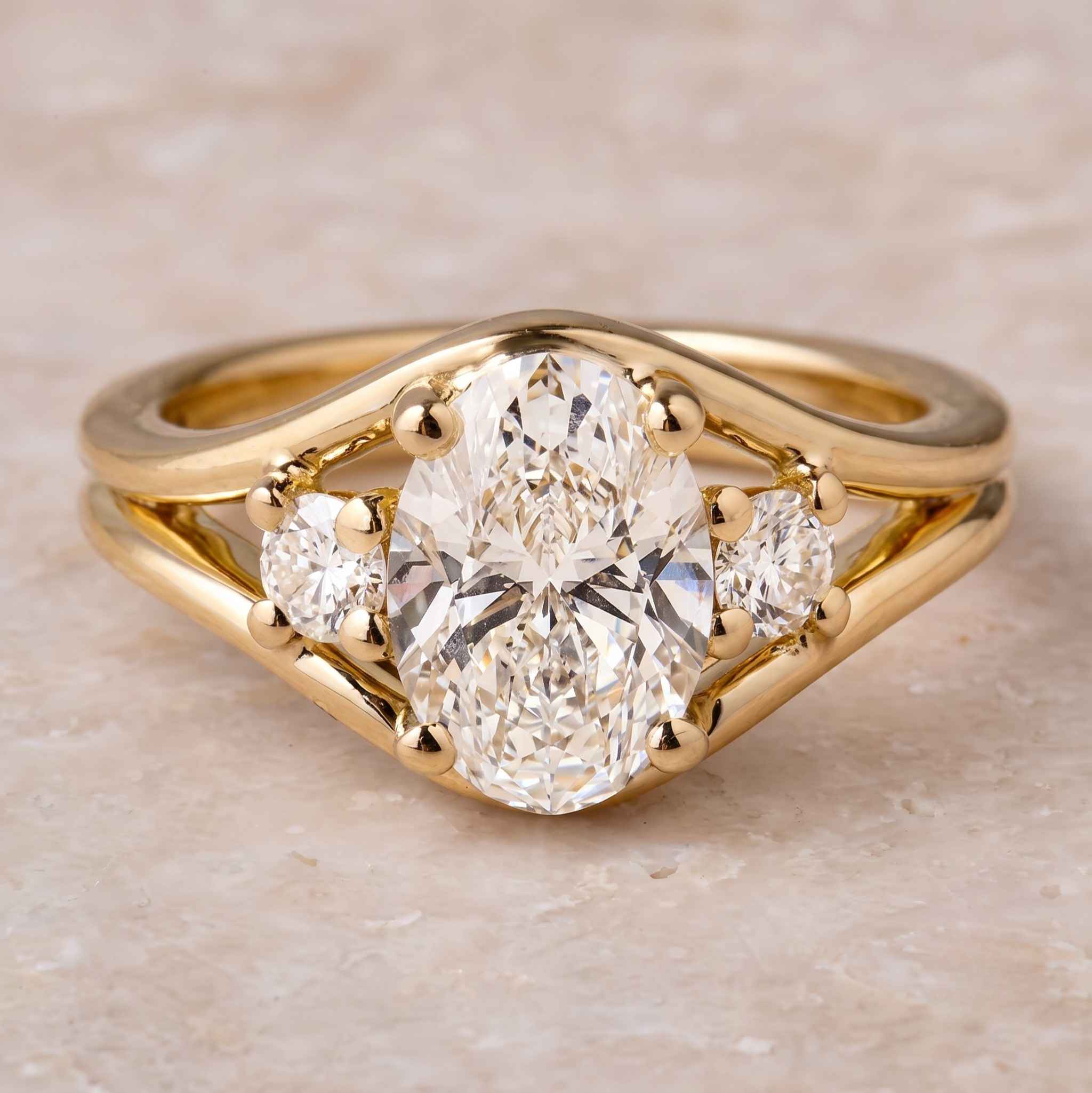 2.39 CT oval and round three-stone diamond engagement ring in yellow gold