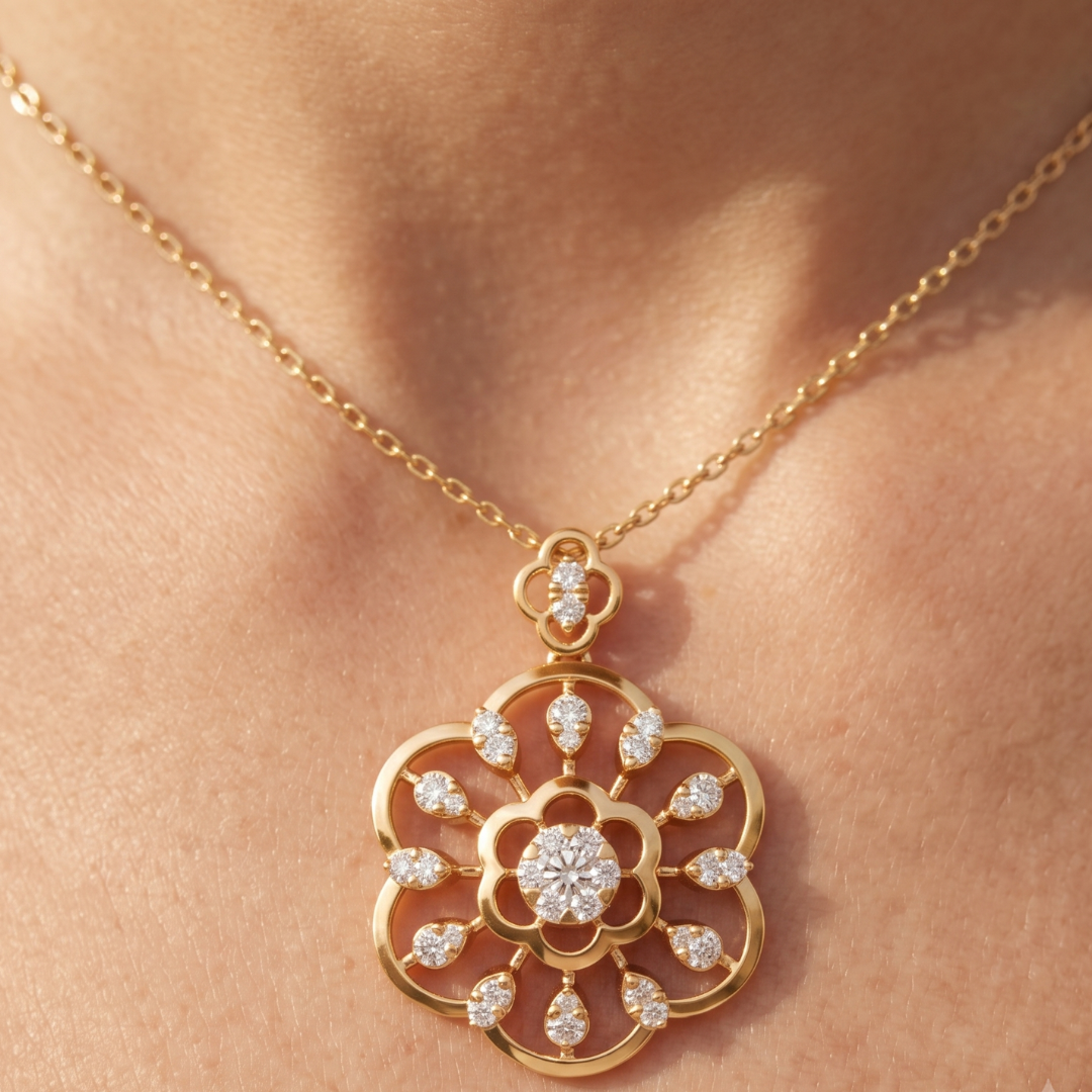 A gold pendant necklace with a floral design set with clear gemstones, shown worn on a person's neck.