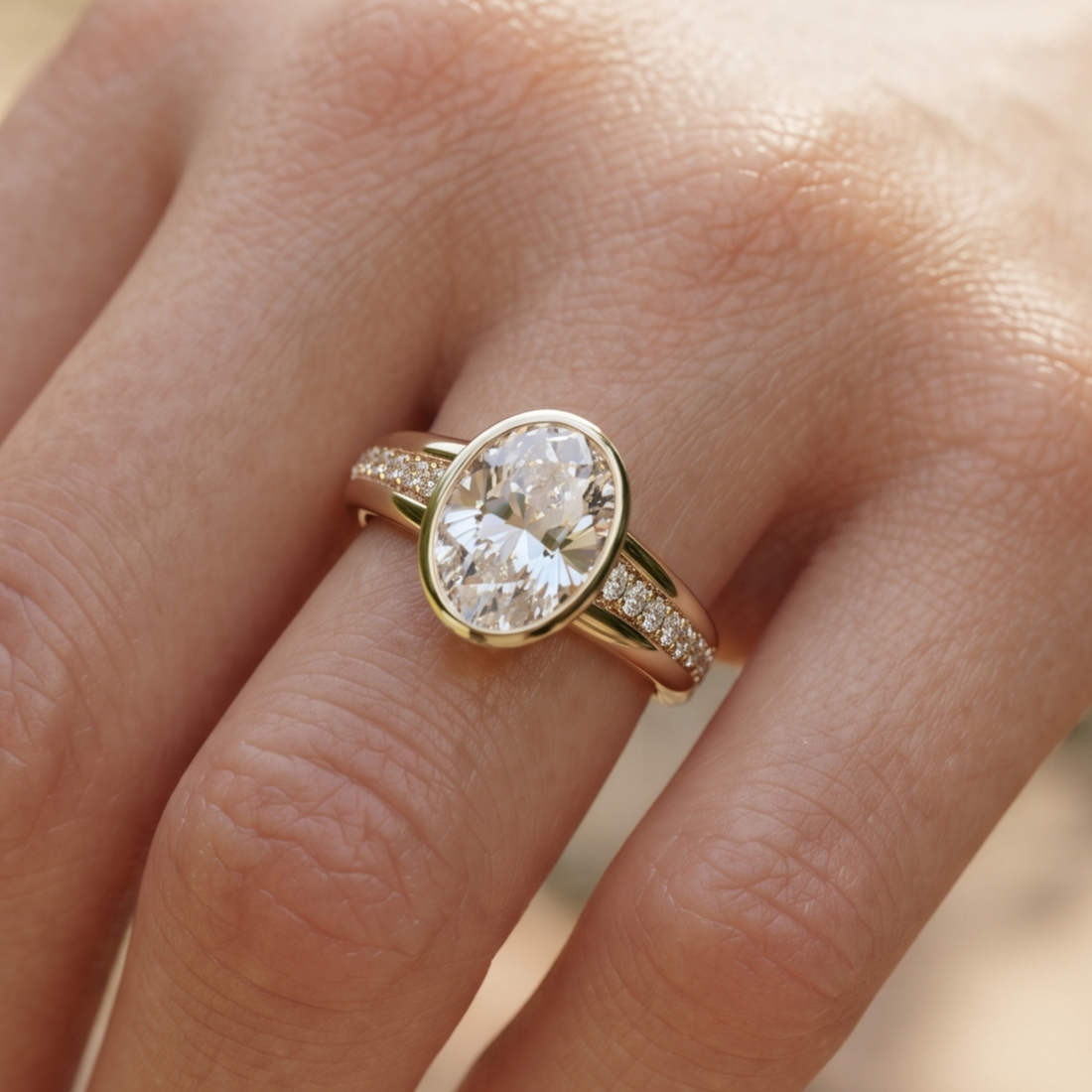 A close-up of a gold ring with a large oval clear gemstone and small pavé accents on the band, worn on a finger.