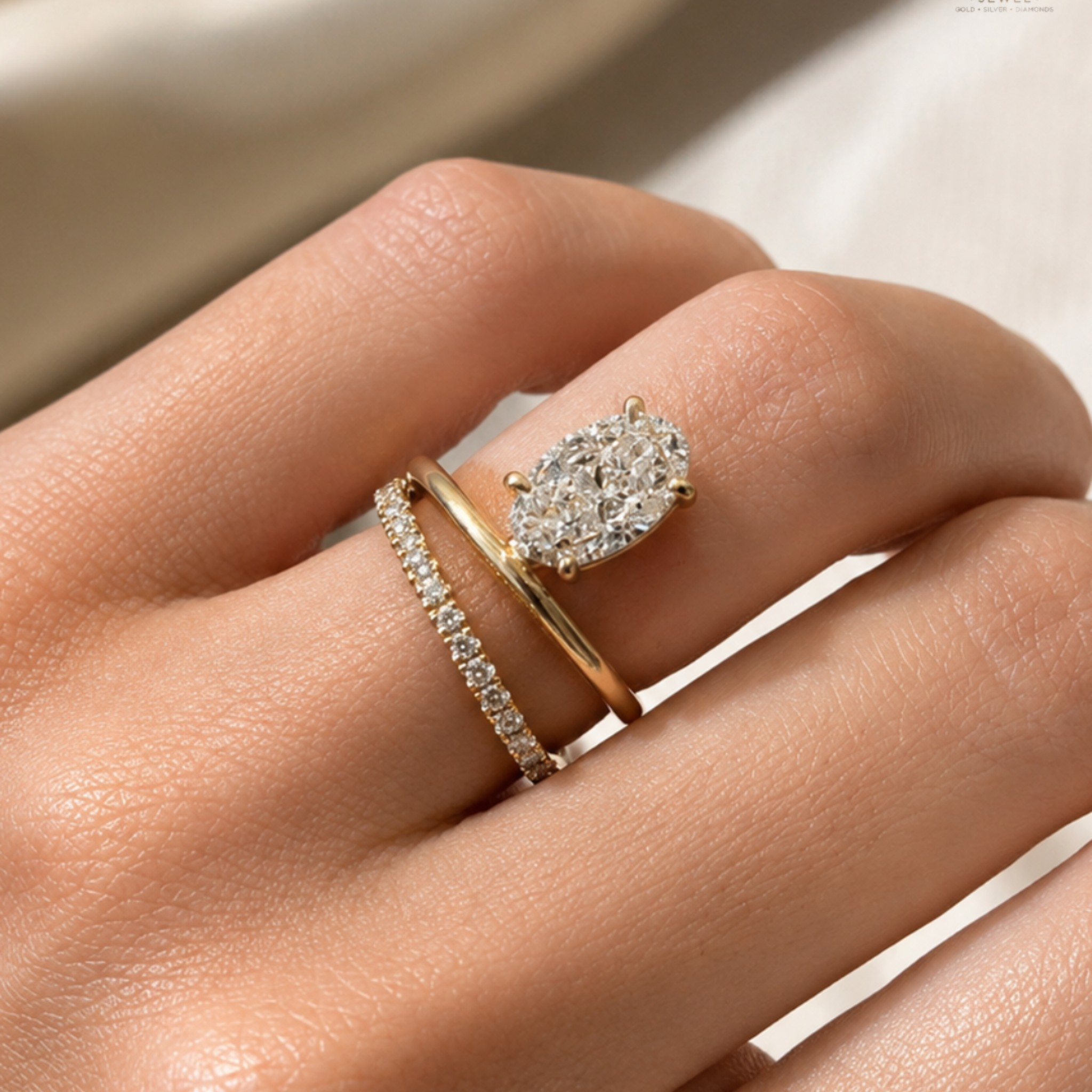 A close-up of a hand wearing two gold rings with diamonds. The primary ring features a large pear-cut diamond cluster, while the secondary ring is a thin diamond-studded band.