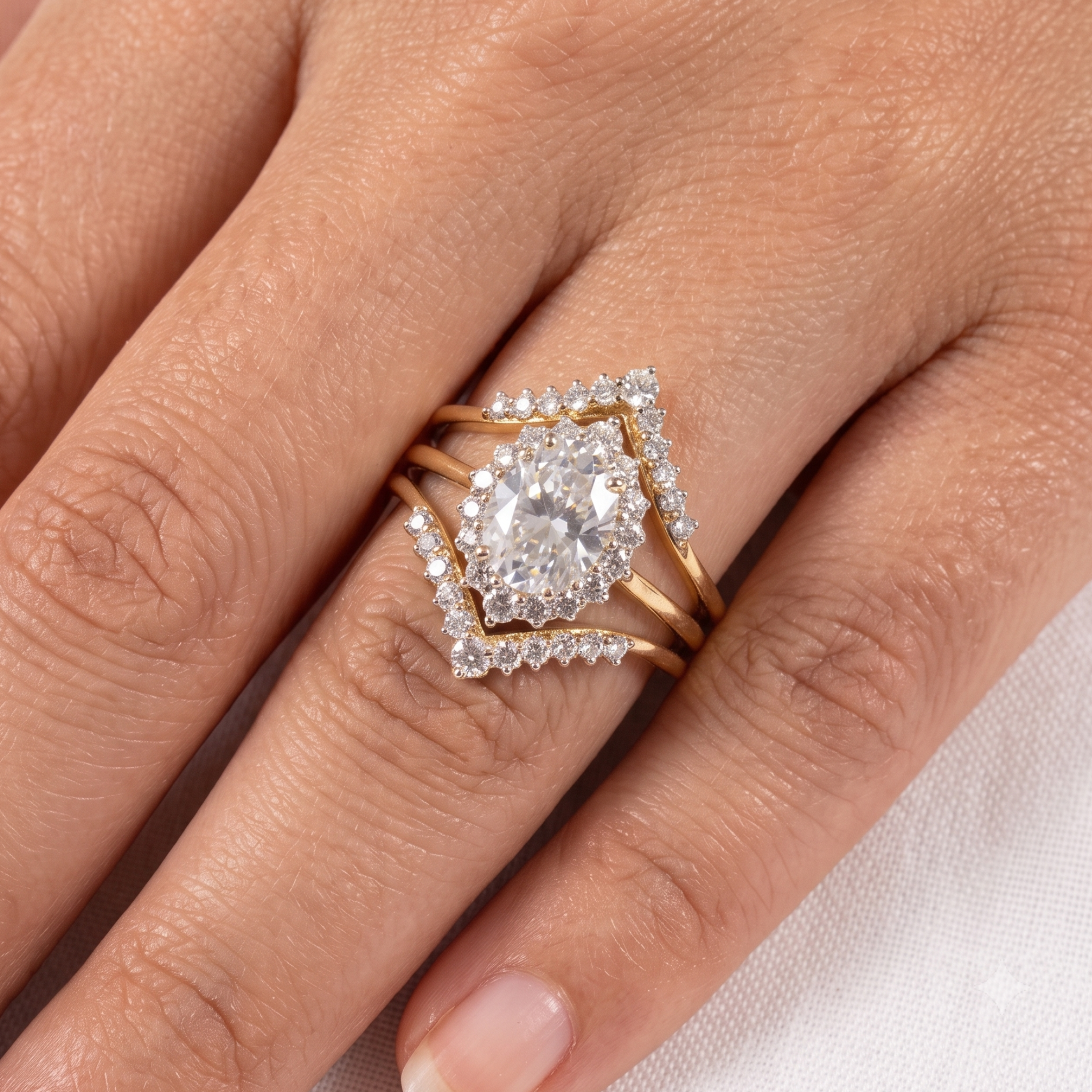 A close-up of a hand wearing a gold ring set with multiple diamond clusters, including a central round-cut diamond surrounded by smaller diamonds in a square halo design.