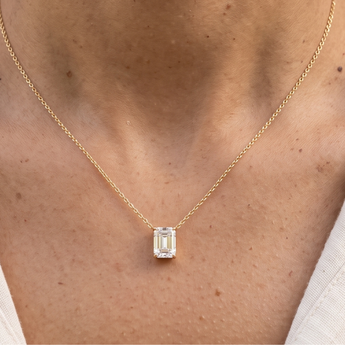 2.58 CT emerald-cut diamond solitaire pendant necklace in polished yellow gold.