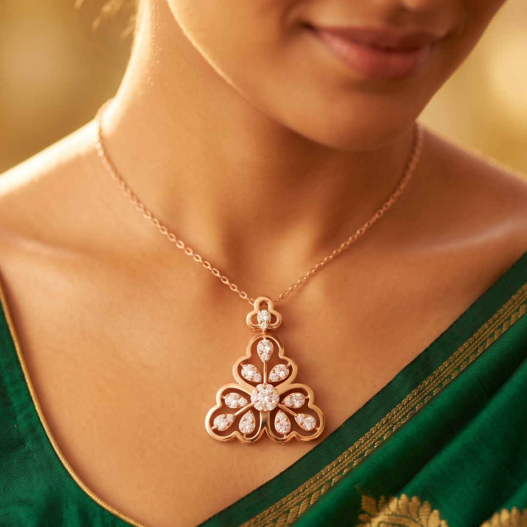 A close-up lifestyle shot of a woman wearing a rose gold pendant necklace with clear stones. The necklace features a delicate chain and a pendant shaped like a stylized flower or lotus, adorned with small clear gemstones in a rose gold setting.