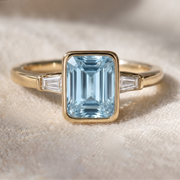 1.35 CT blue step-cut three-stone ring in yellow gold
