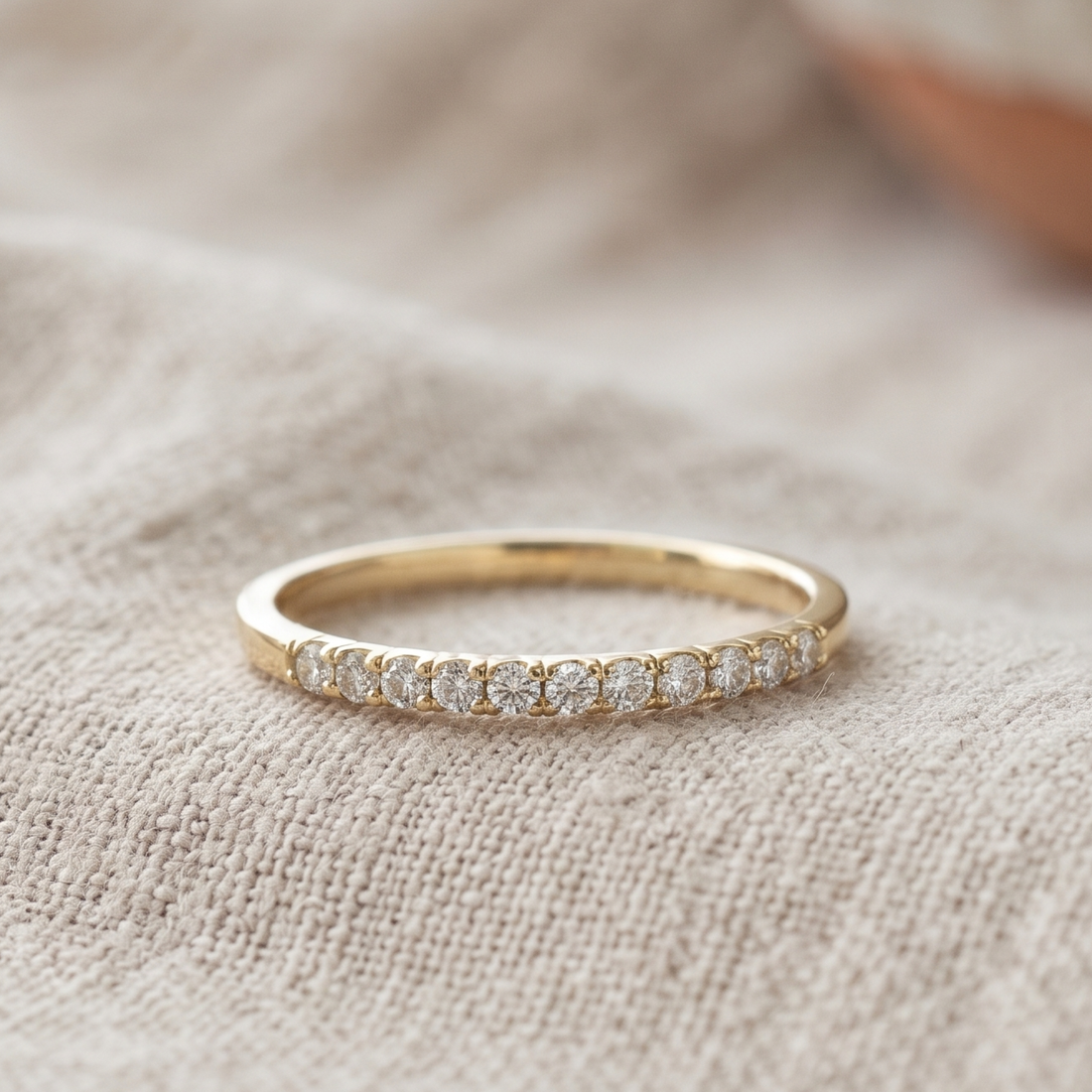 Front view of a 0.77 CTW round diamond half-eternity wedding band in yellow gold.