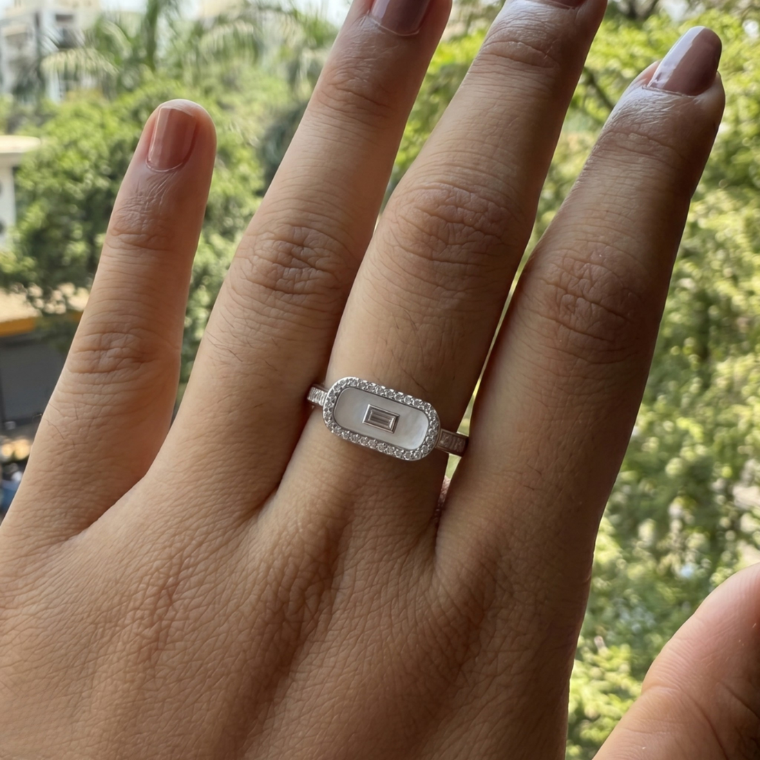 Geometric diamond ring featuring a luminous elongated mother-of-pearl center.