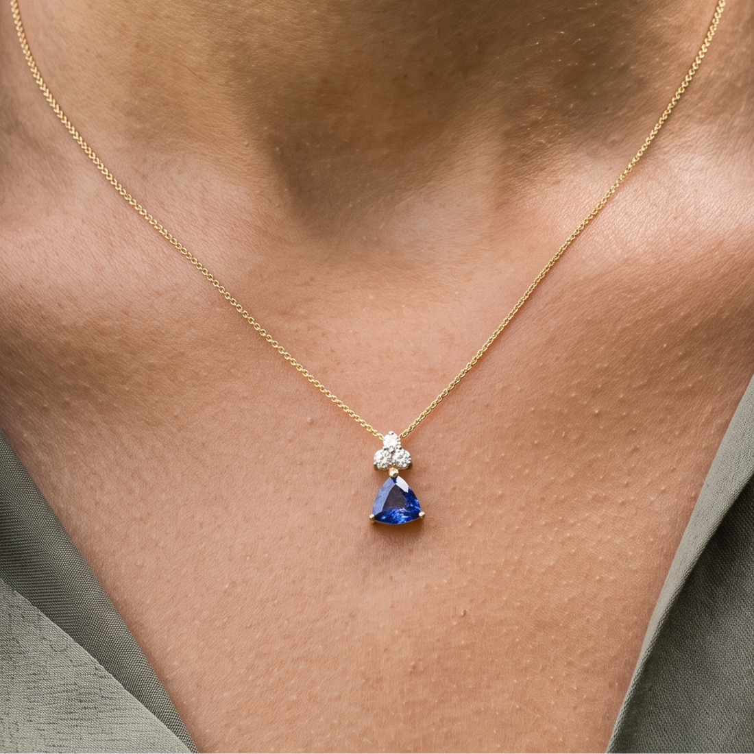 0.96 CTW blue trillion pendant necklace with a 6 mm center stone and three round diamond accents.