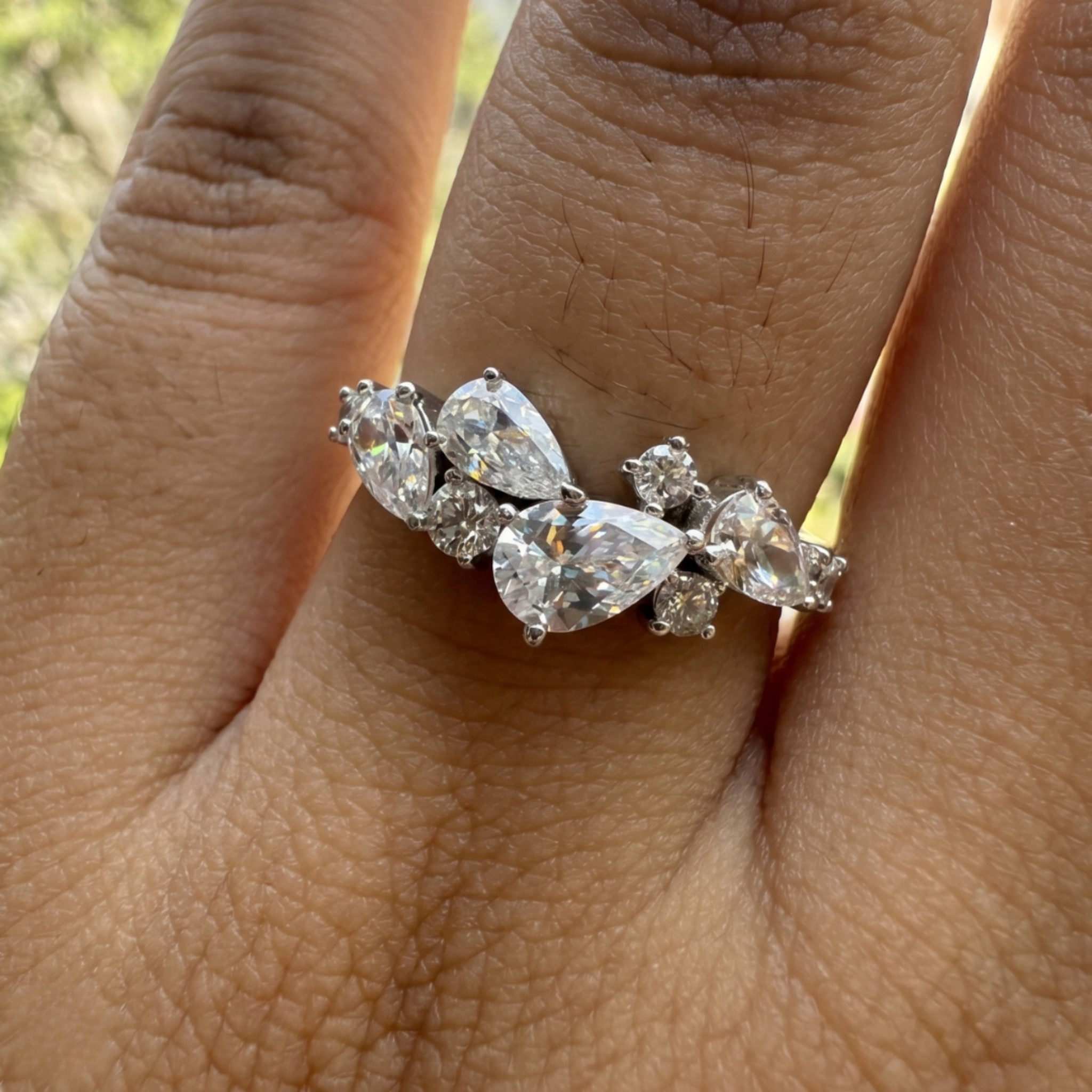 Handcrafted lab-grown diamond ring with pear and round brilliant stones.