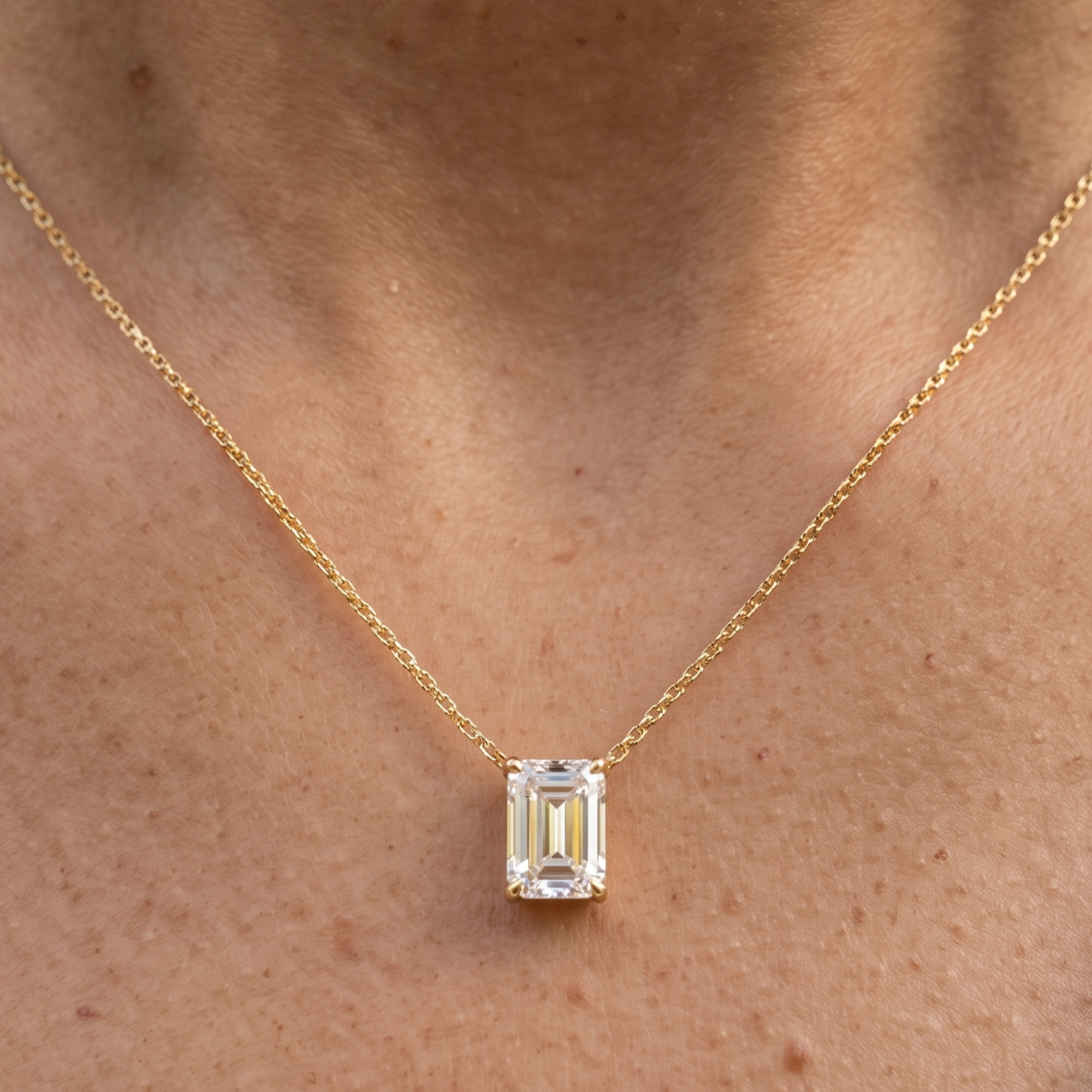 2.58 CT emerald-cut diamond solitaire pendant necklace in polished yellow gold.