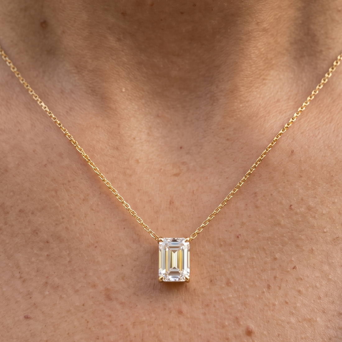 2.58 CT emerald-cut diamond solitaire pendant necklace in polished yellow gold.