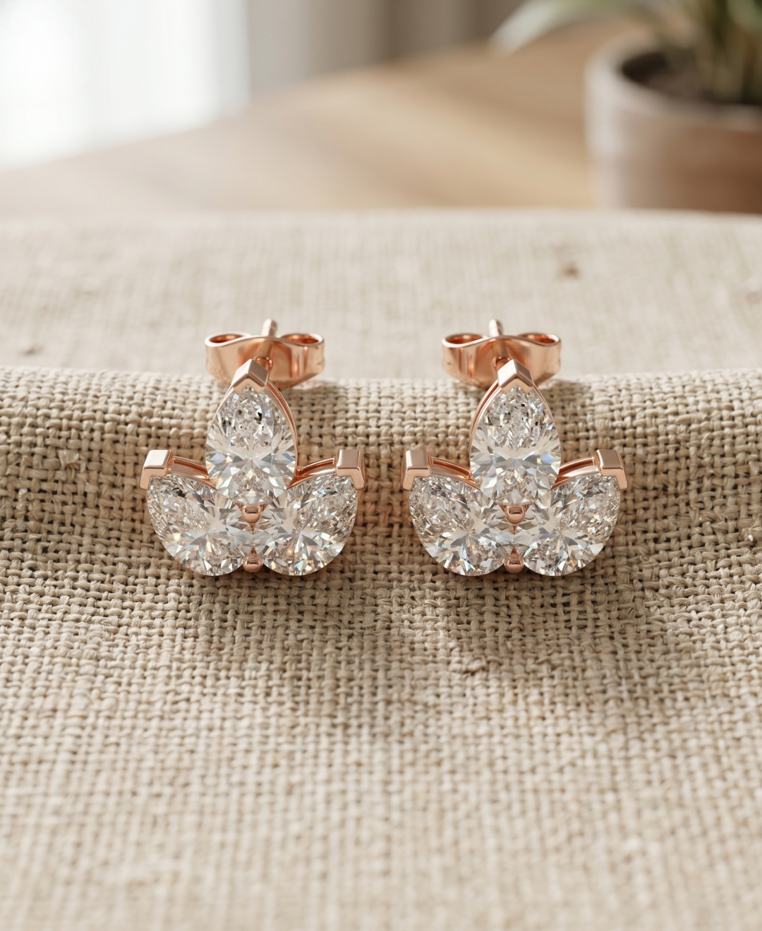 Pear-shaped cluster diamond earrings in rose gold with elegant floral fan design.