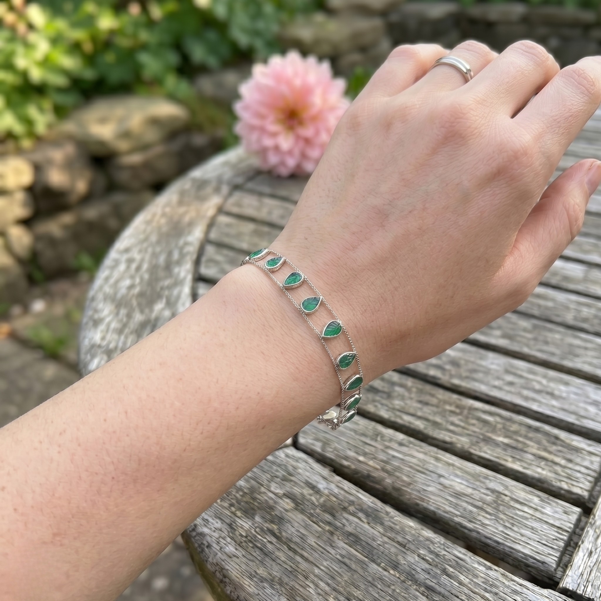 Elegant botanical bracelet with pear and marquise-shaped green crystal stations.