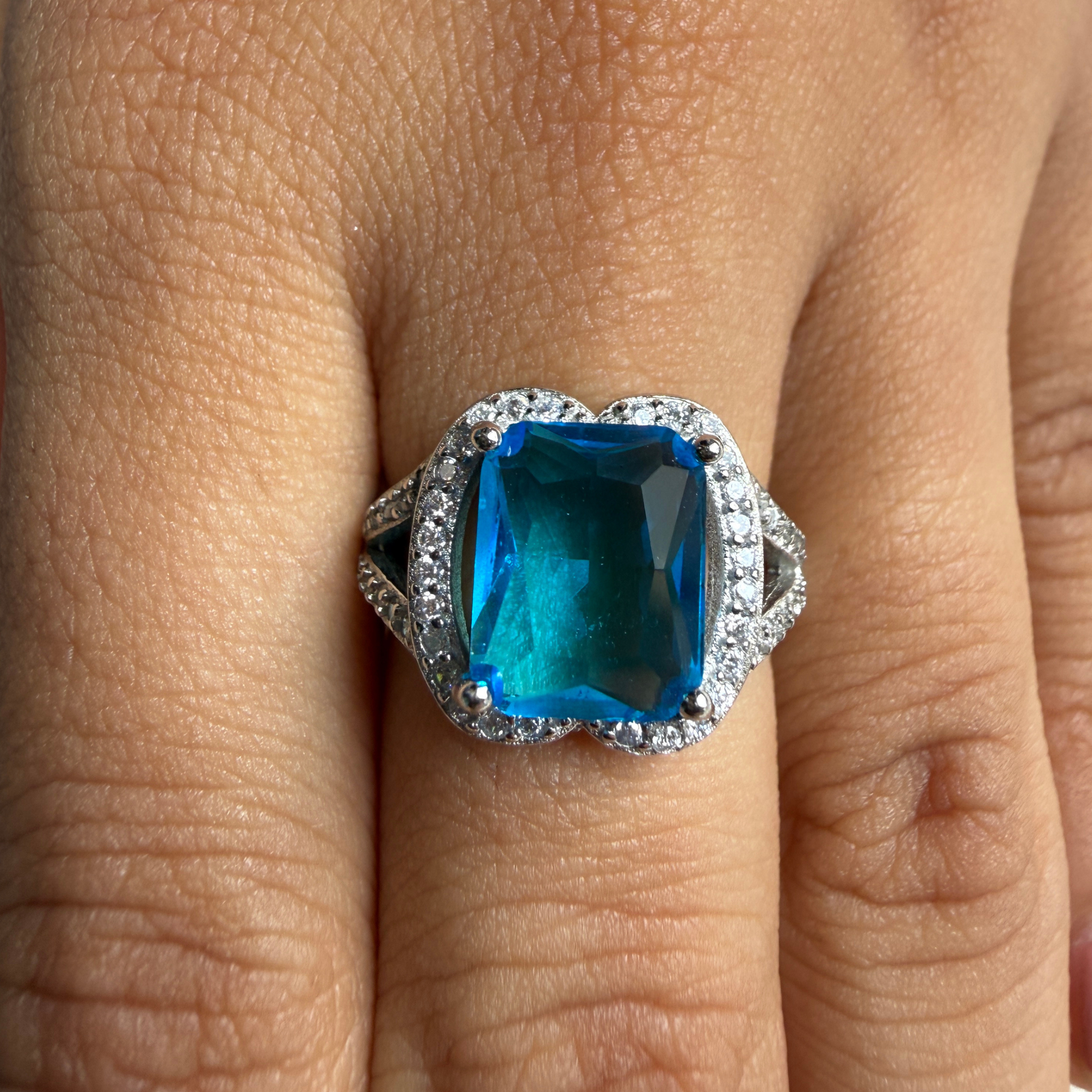 Blue emerald-cut gemstone and lab-grown diamond halo ring by Kiashaa Jewellery.