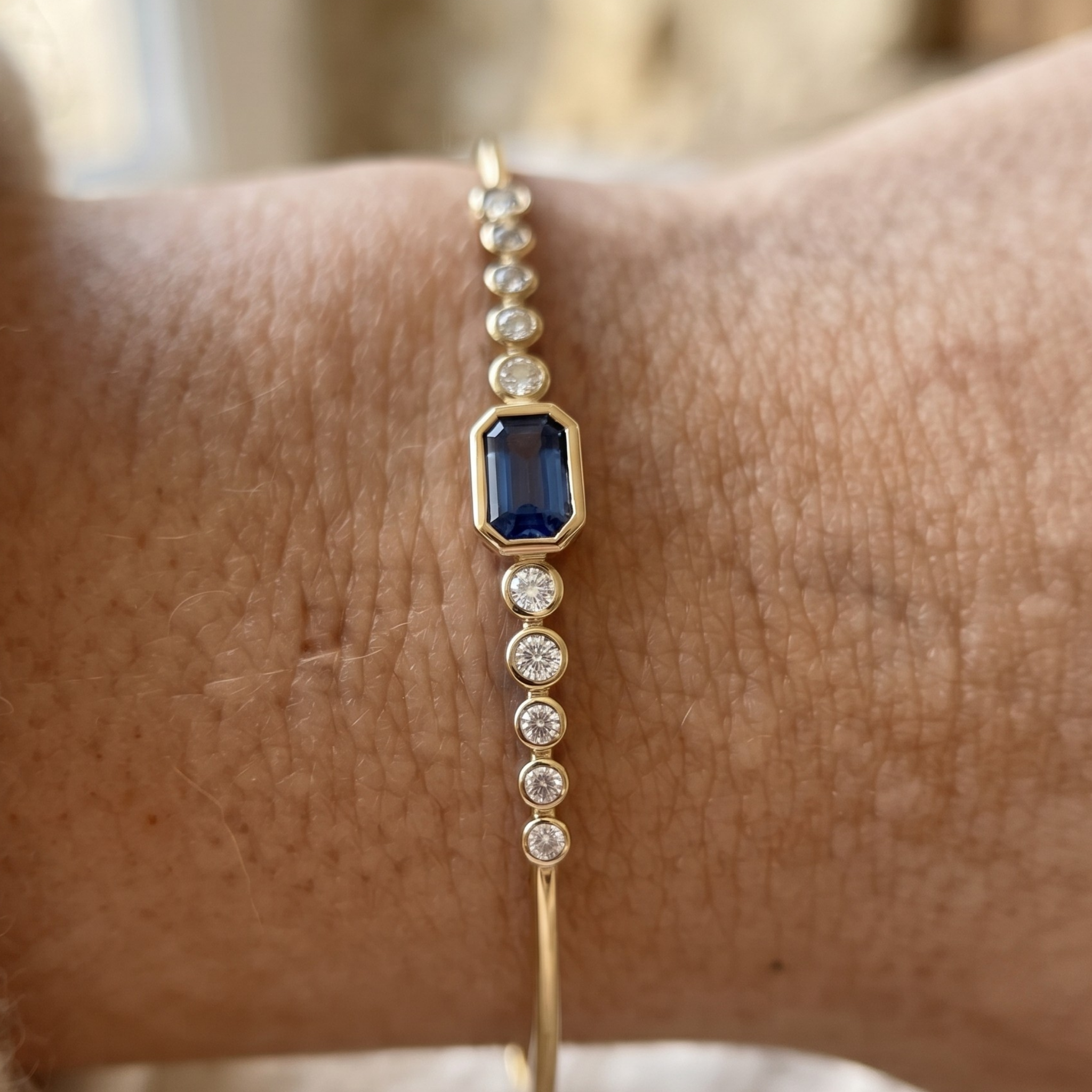 Kiashaa Jewellery 1.582 CTW blue emerald and round diamond bangle in polished yellow gold.