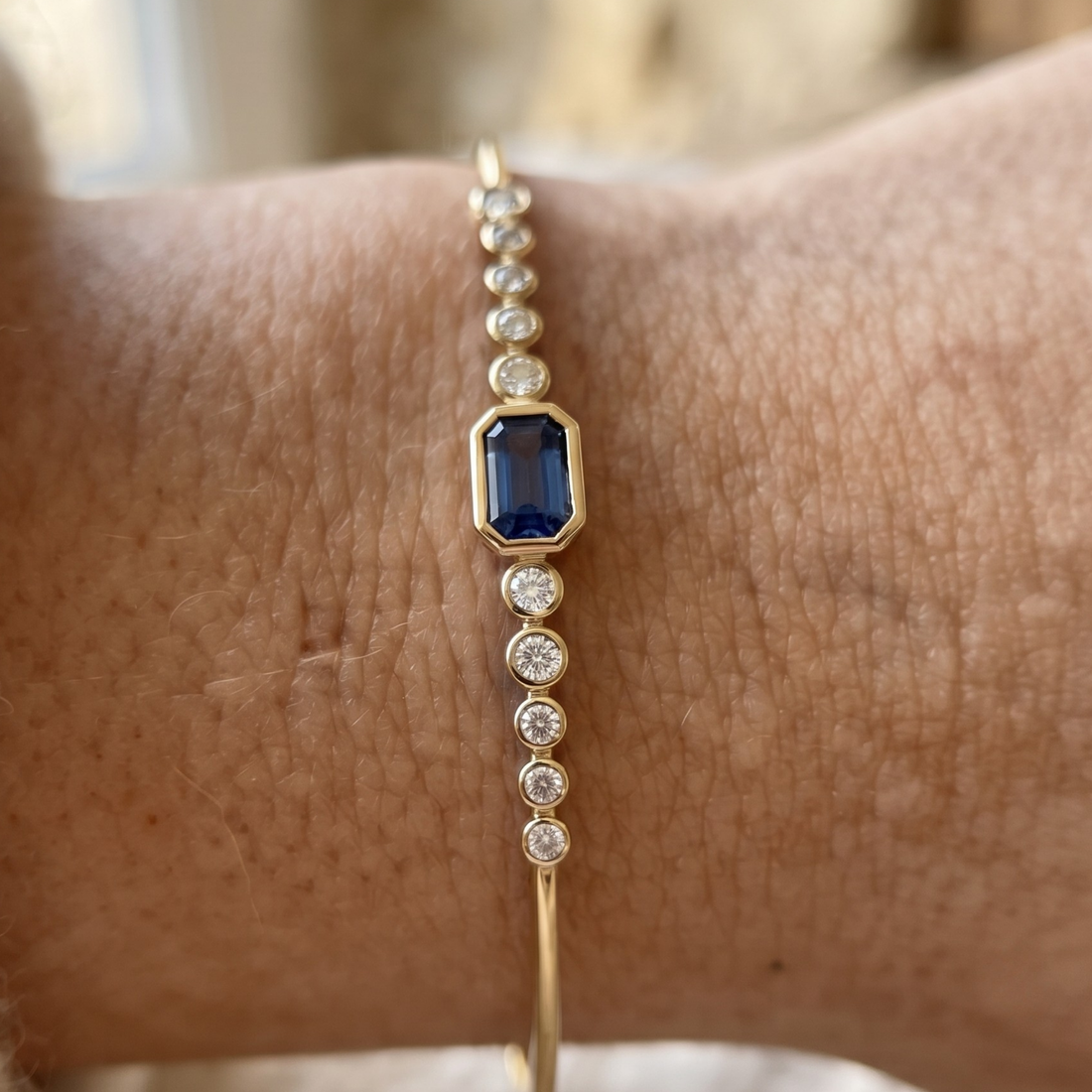 Kiashaa Jewellery 1.582 CTW blue emerald and round diamond bangle in polished yellow gold.