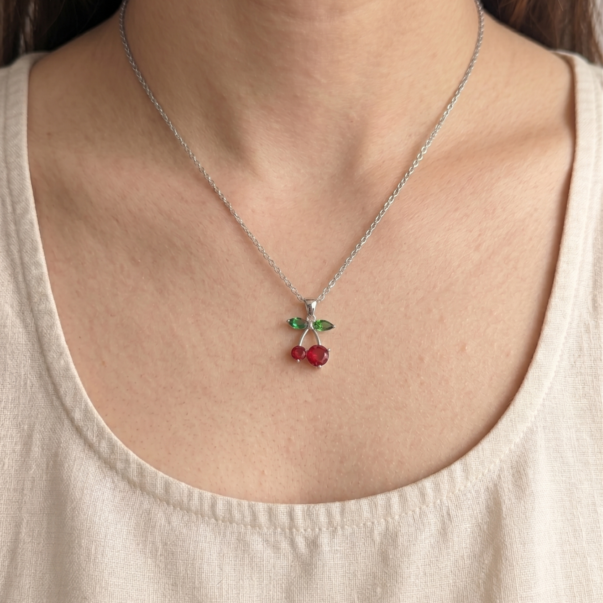 Luxury necklace featuring two green diamonds and two vivid red gemstone accents.