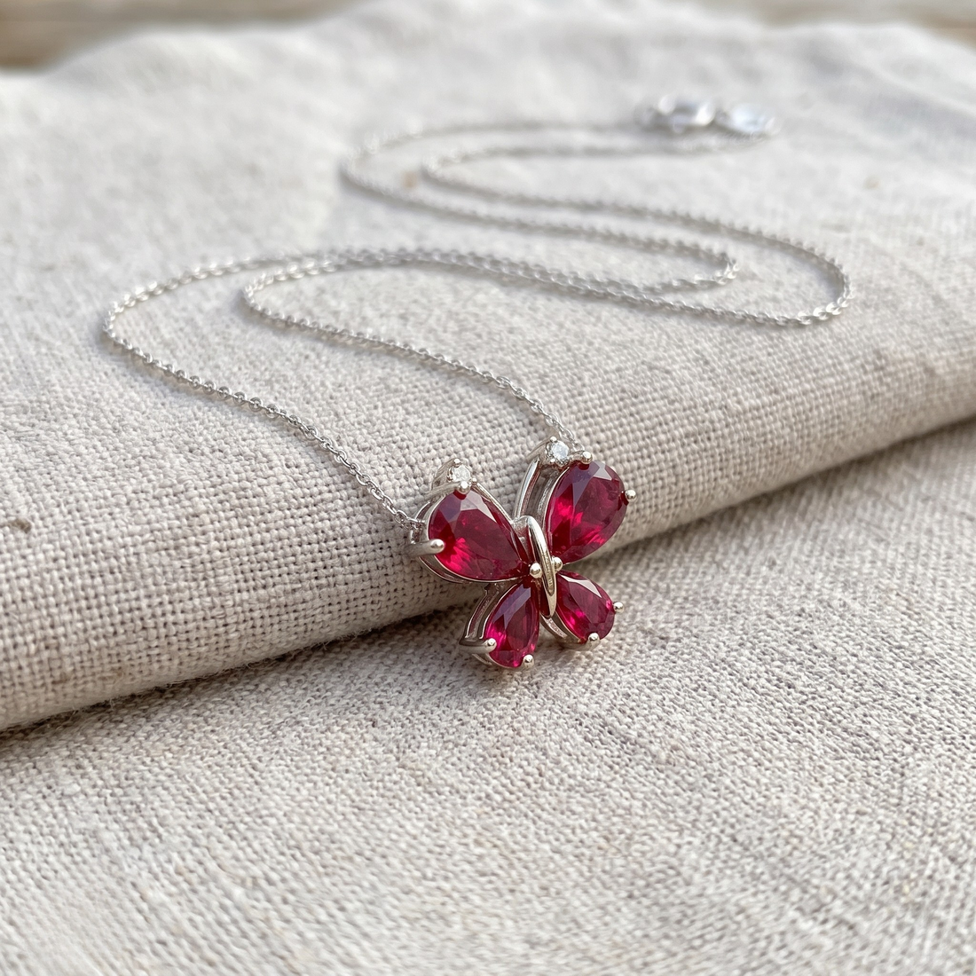 Red pear gemstone butterfly pendant necklace with lab-grown diamond accents by Kiashaa Jewellery.