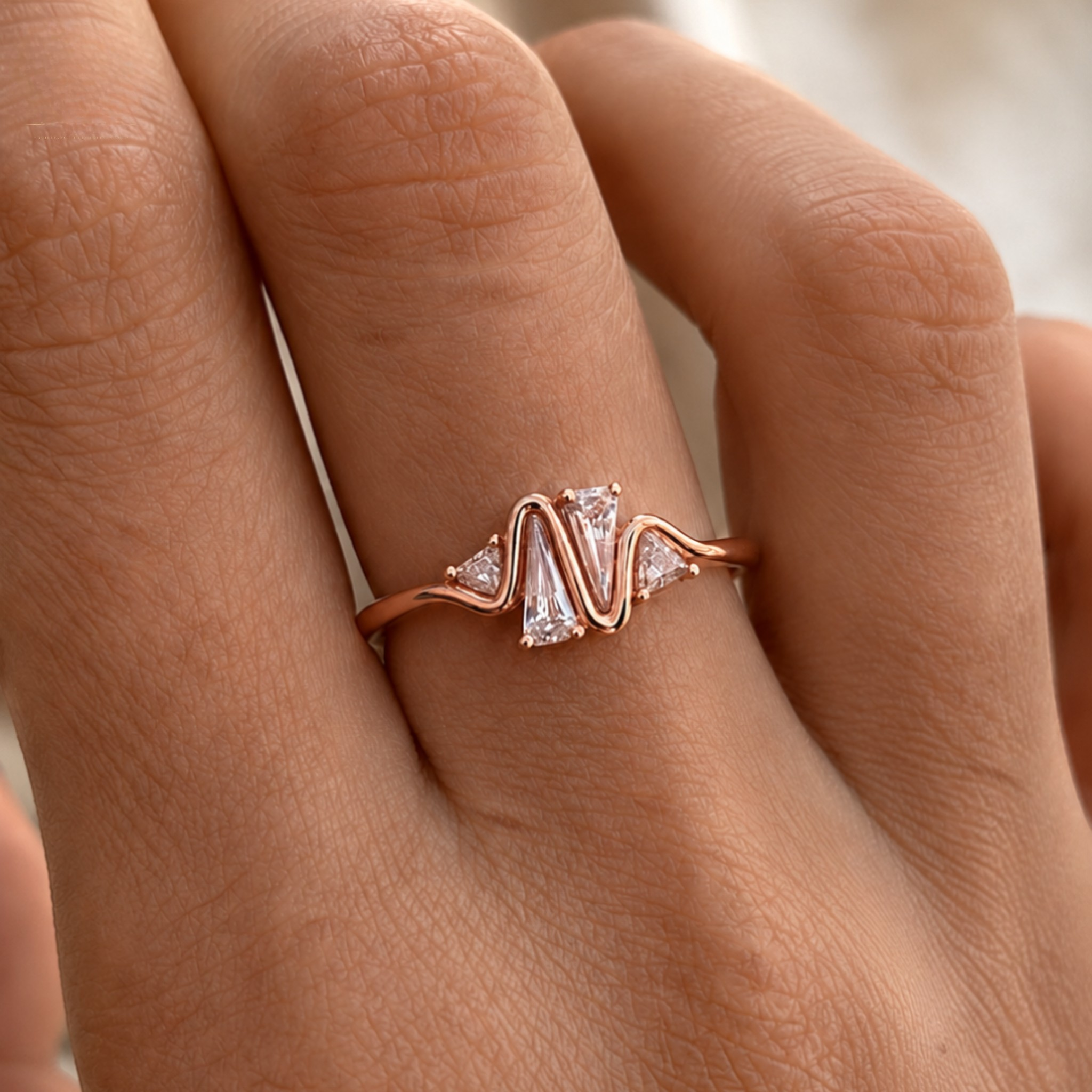 A close-up of a hand wearing a rose gold ring with a wavy, zig-zag design and clear marquise-cut gemstones.