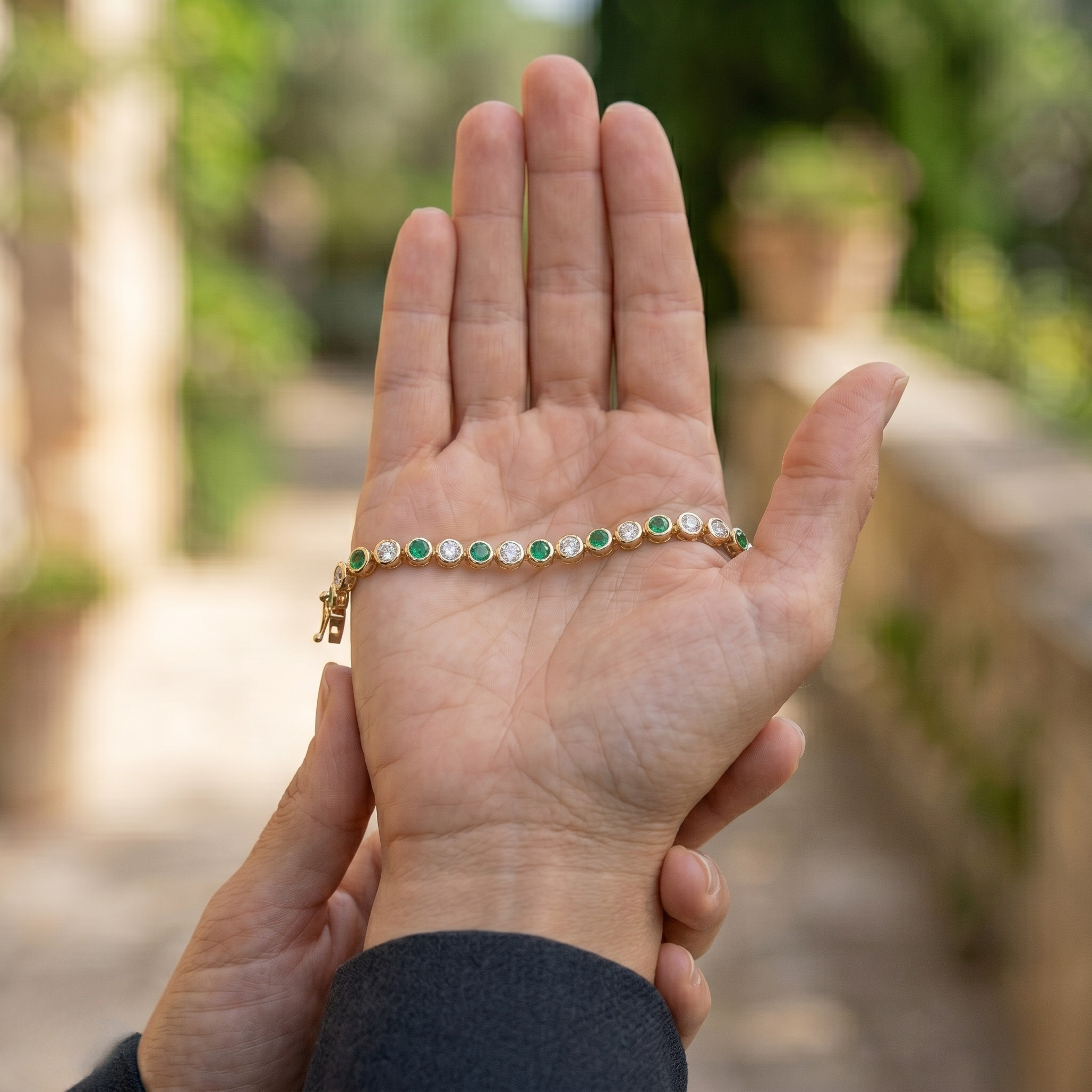 Alternating green gemstone and white diamond bracelet with round bezel-set stones.