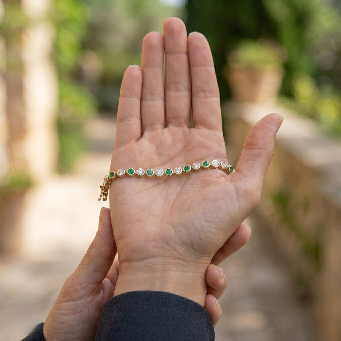 Alternating green gemstone and white diamond bracelet with round bezel-set stones.