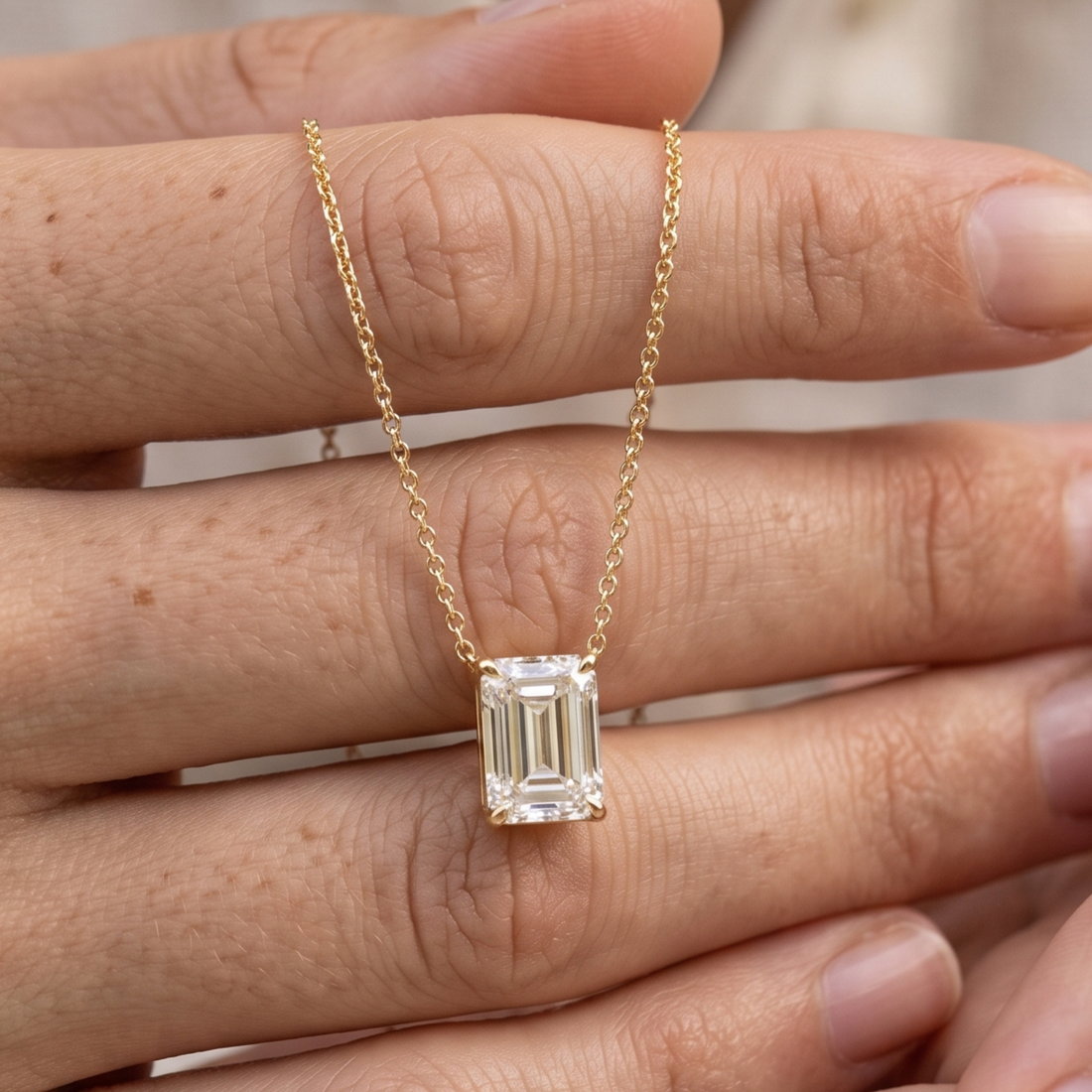 2.58 CT emerald-cut diamond solitaire pendant necklace in polished yellow gold.