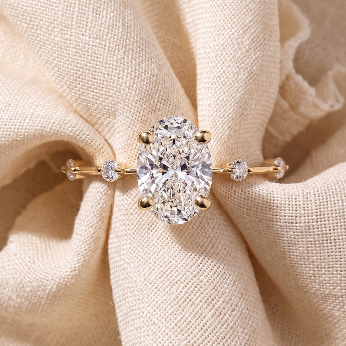 Four-prong oval diamond ring with delicate round side stones