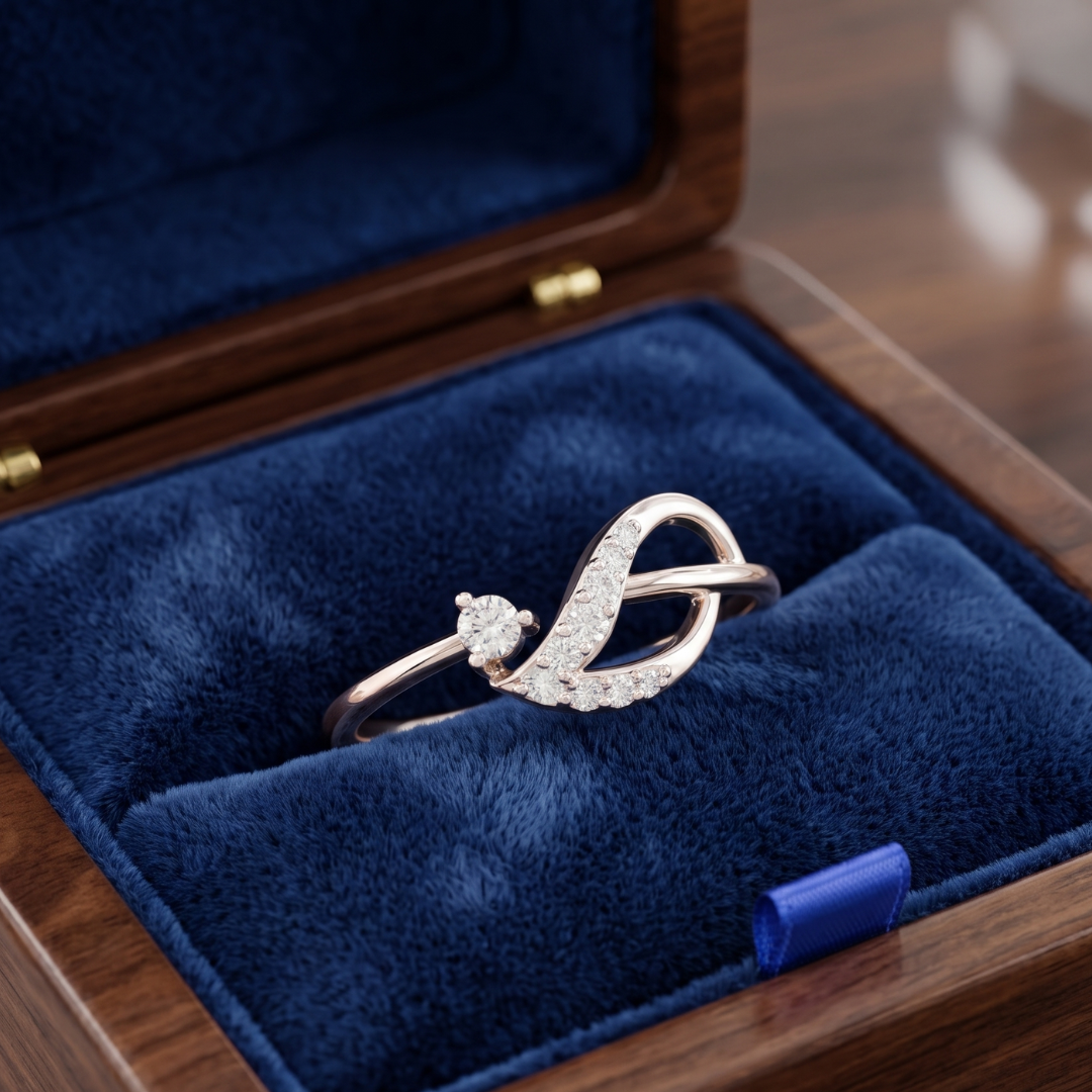 A silver-toned ring with a curved, diamond-encrusted design resting in a blue velvet-lined wooden jewelry box.