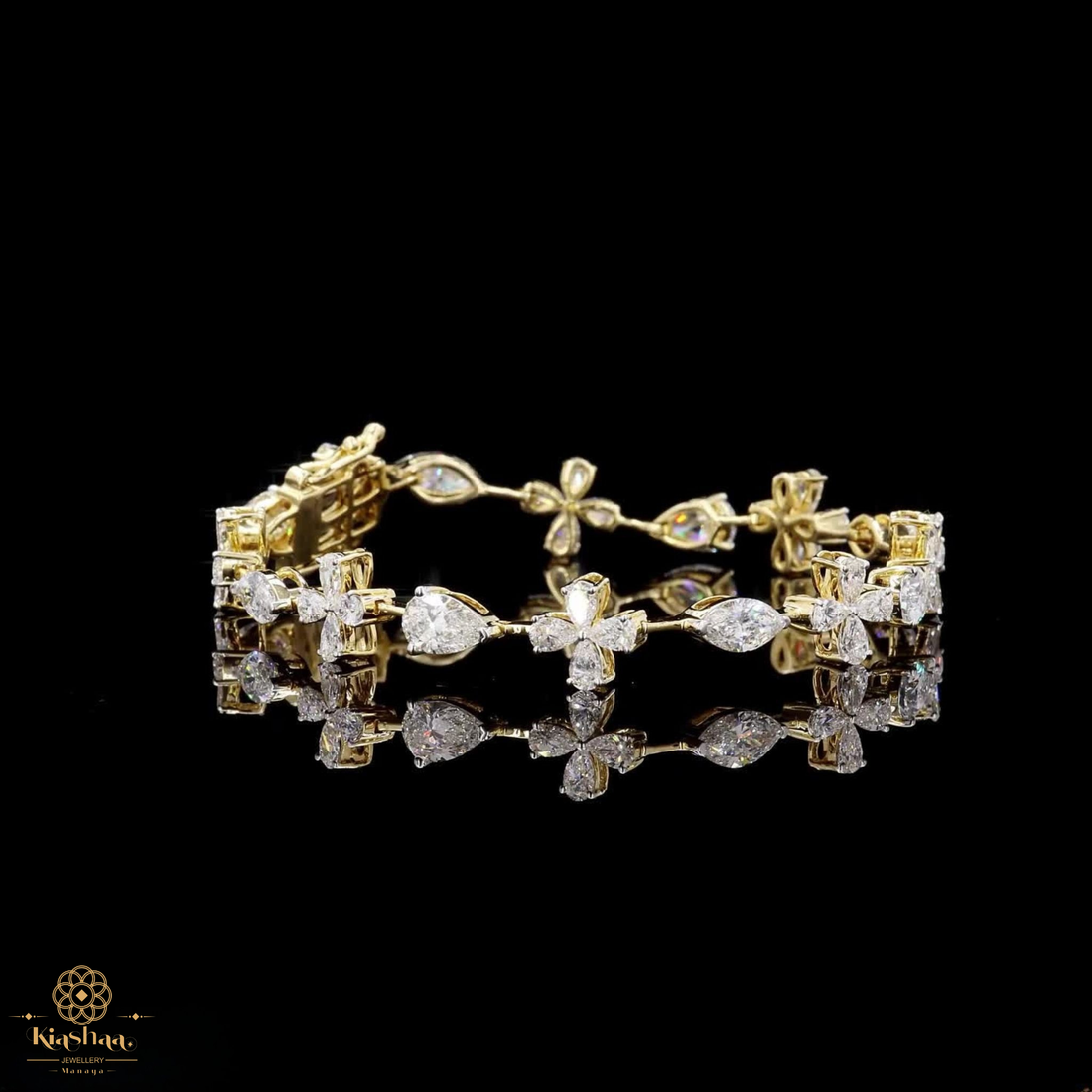A gold bracelet adorned with clear gemstones in floral and marquise-shaped settings, displayed on a reflective black surface against a black background. A small 'Kavuti' brand logo is visible in the bottom-left corner.