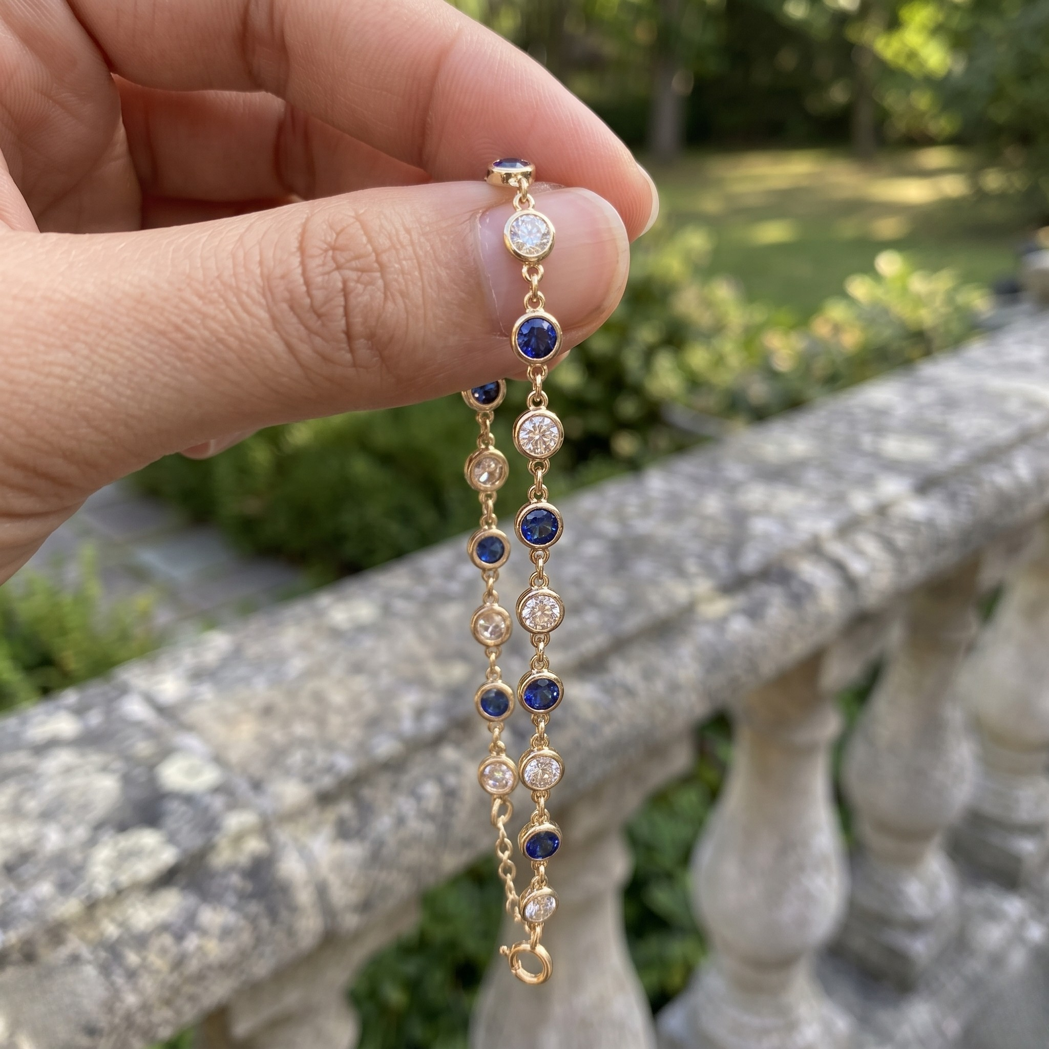 Luxury tennis bracelet with round blue gemstones and brilliant white diamonds.