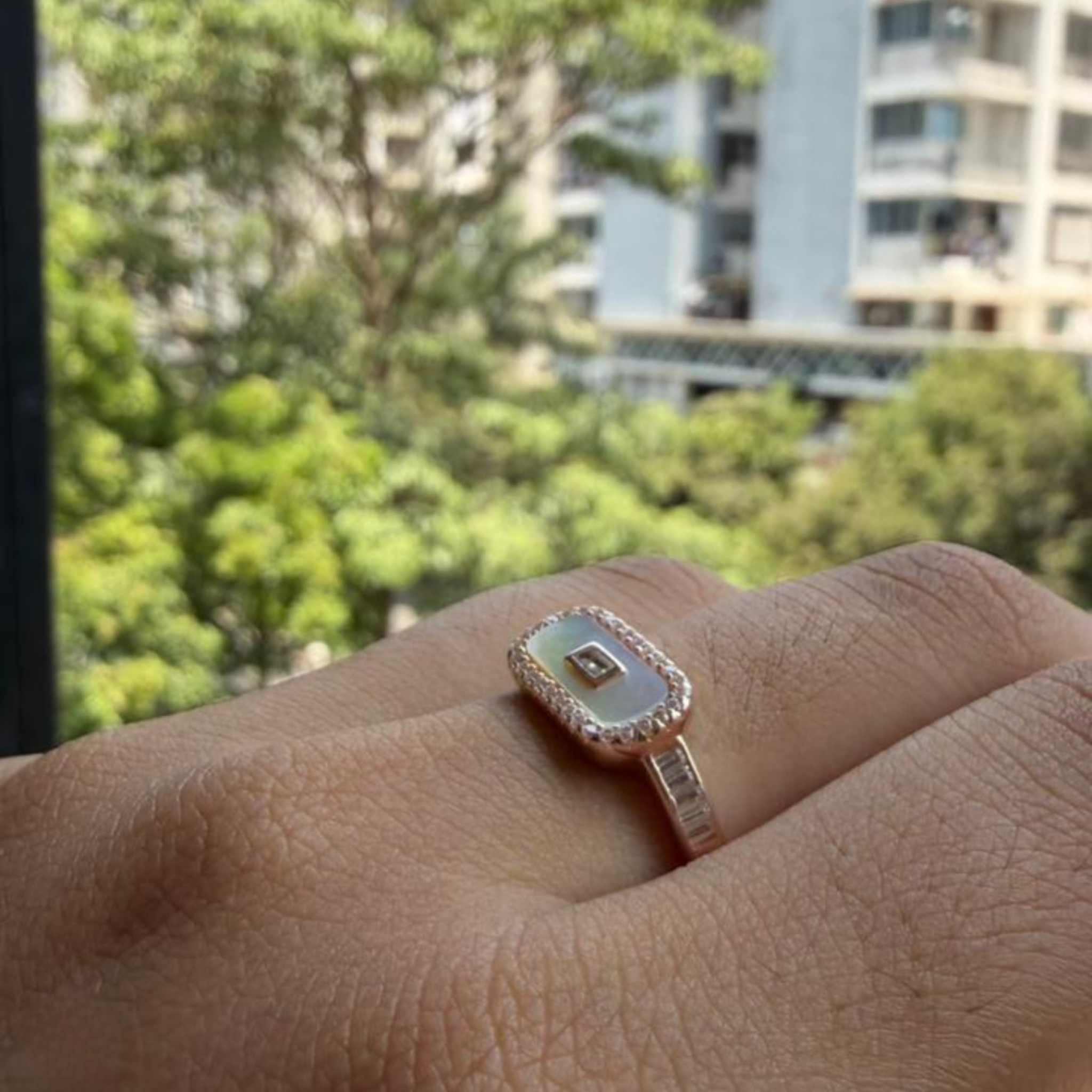 Geometric diamond ring featuring a luminous elongated mother-of-pearl center.