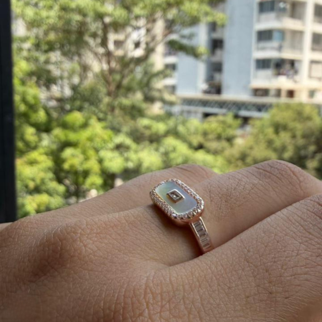 Geometric diamond ring featuring a luminous elongated mother-of-pearl center.
