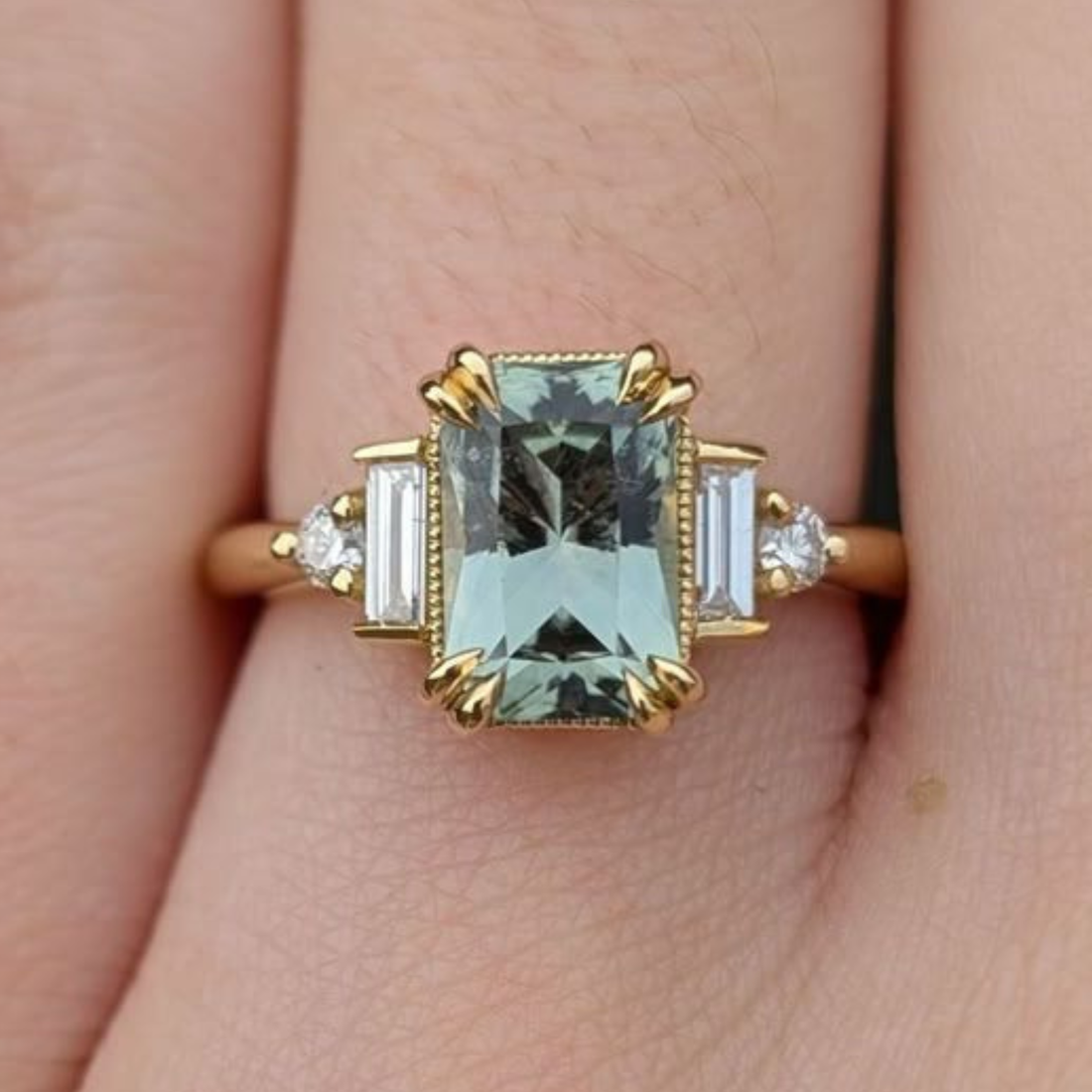  Green emerald-cut engagement ring with round brilliant diamond accents