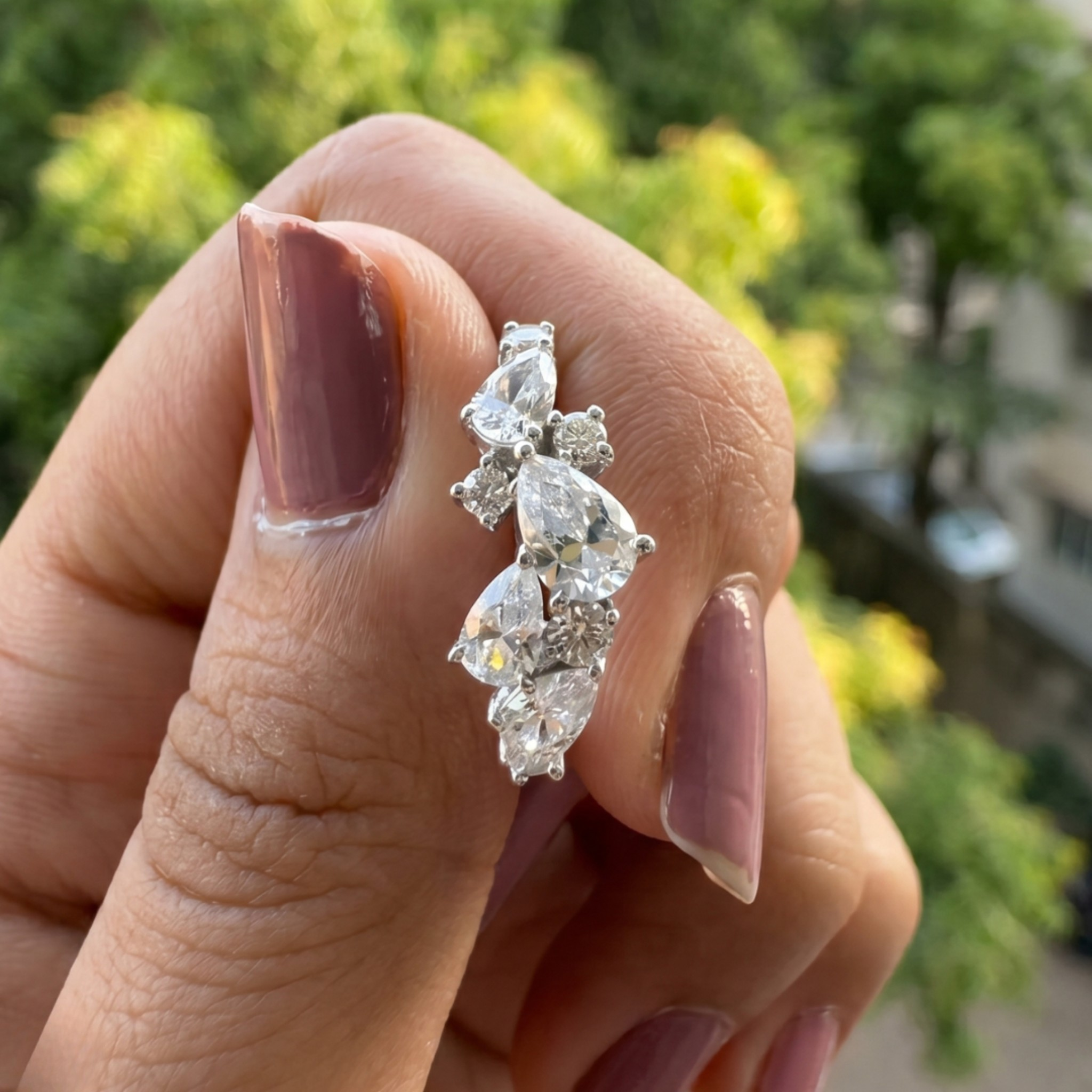 Handcrafted lab-grown diamond ring with pear and round brilliant stones.