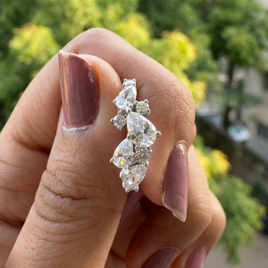 Handcrafted lab-grown diamond ring with pear and round brilliant stones.