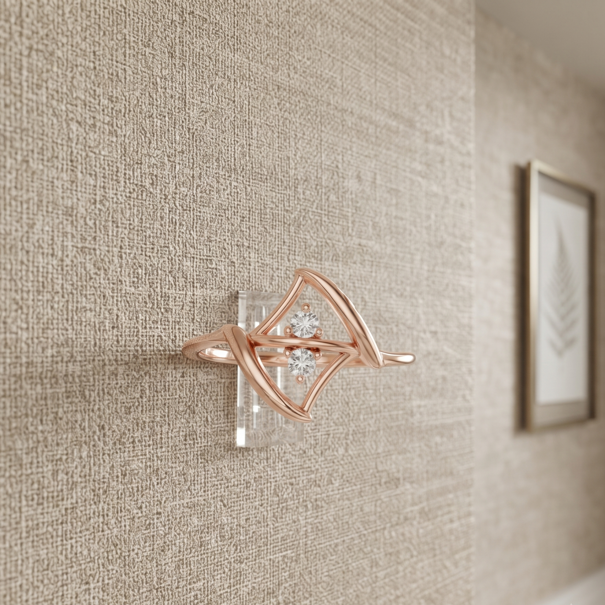A rose gold wall-mounted jewelry display stand holding a diamond ring, set against a textured beige wallpaper background.