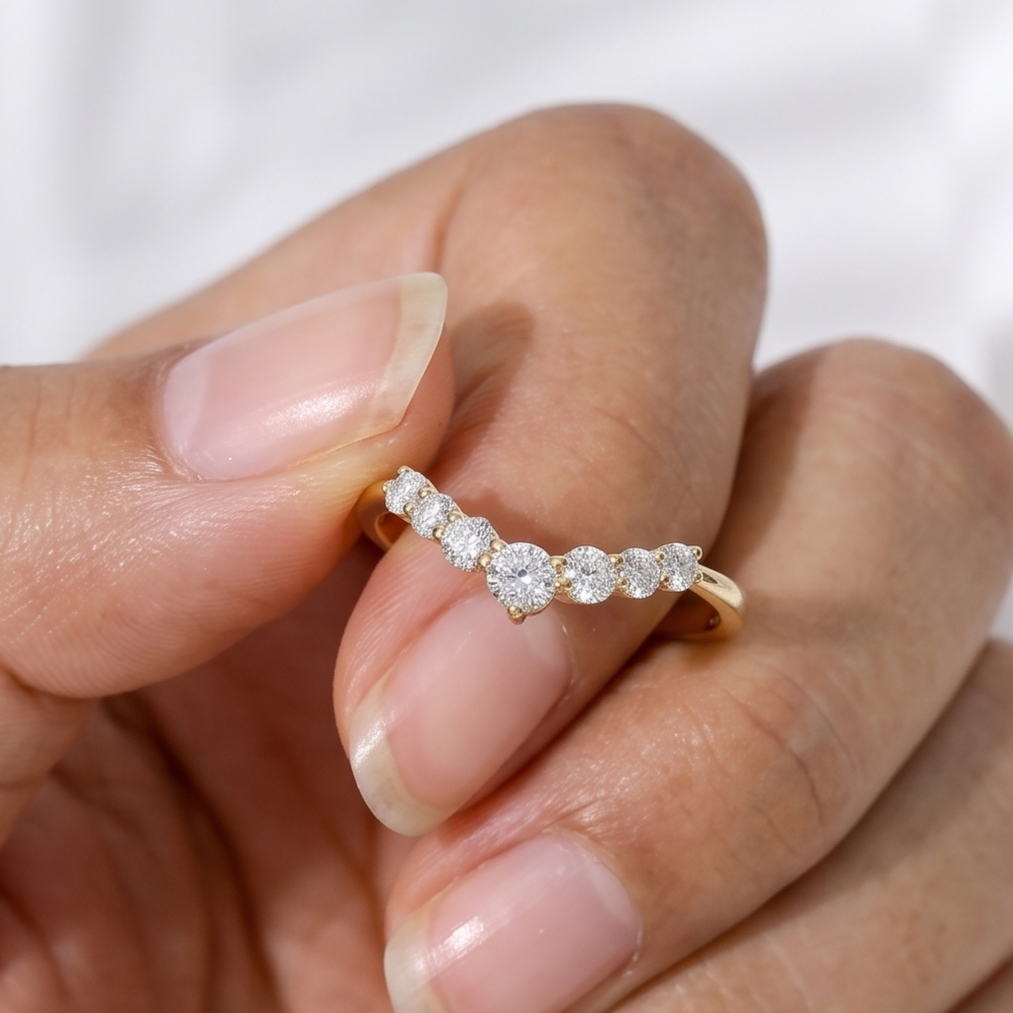 Yellow gold curved diamond wedding band with seven round diamonds