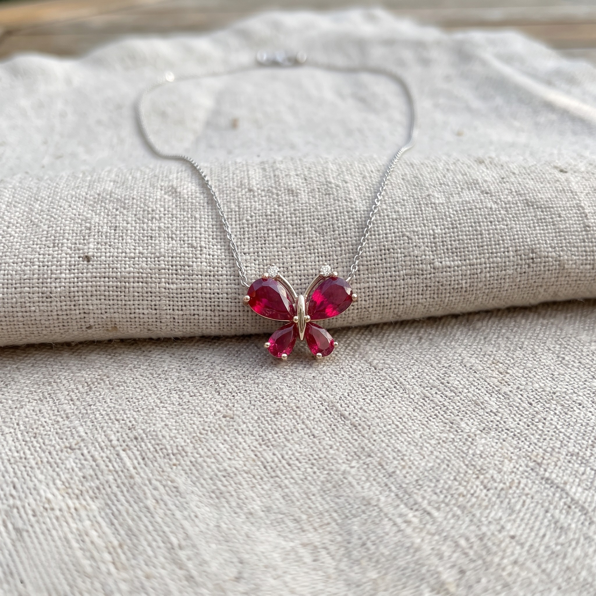 Red pear gemstone butterfly pendant necklace with lab-grown diamond accents by Kiashaa Jewellery.