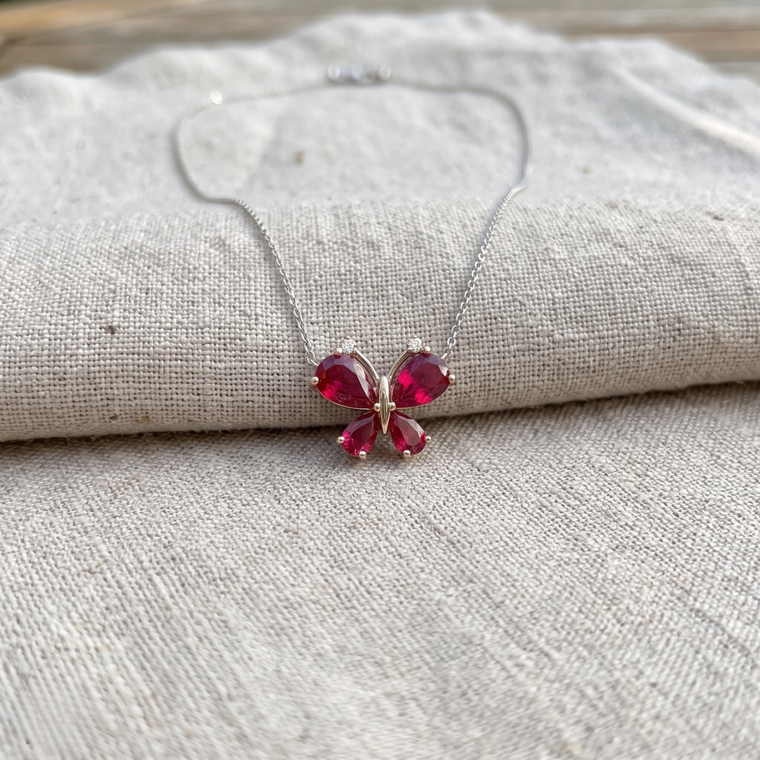 Red pear gemstone butterfly pendant necklace with lab-grown diamond accents by Kiashaa Jewellery.