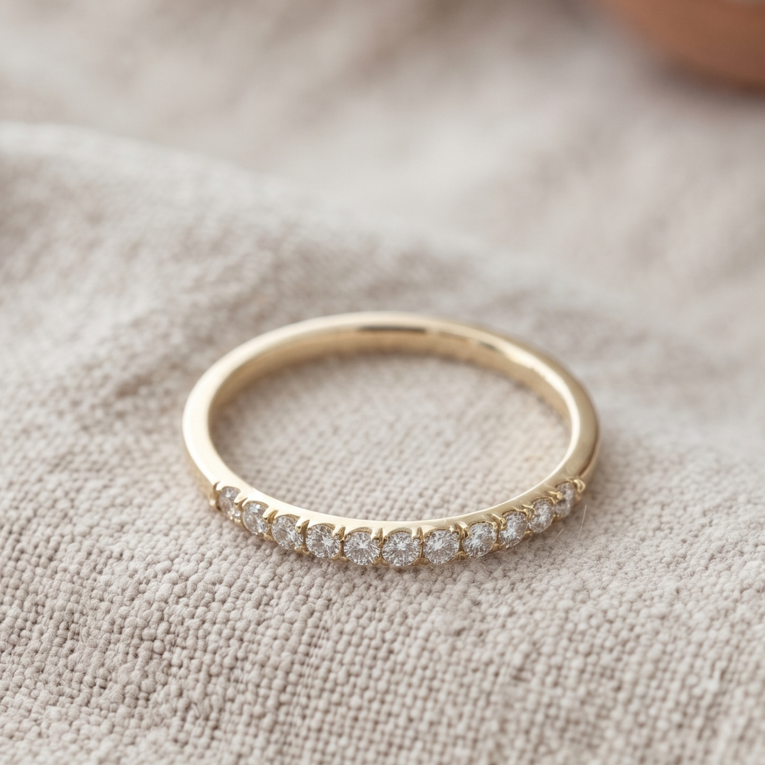 Front view of a 0.77 CTW round diamond half-eternity wedding band in yellow gold.